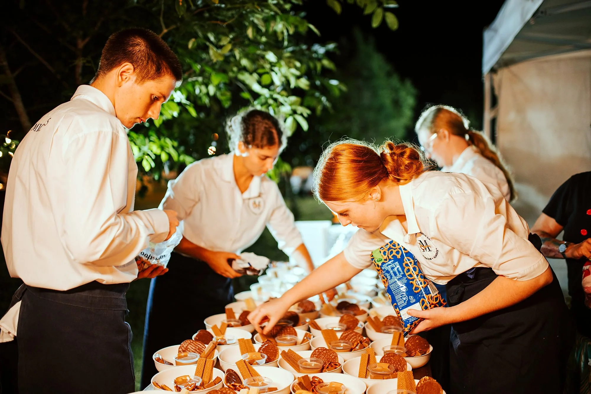Michels team plating canapés together at an outdoor evening event