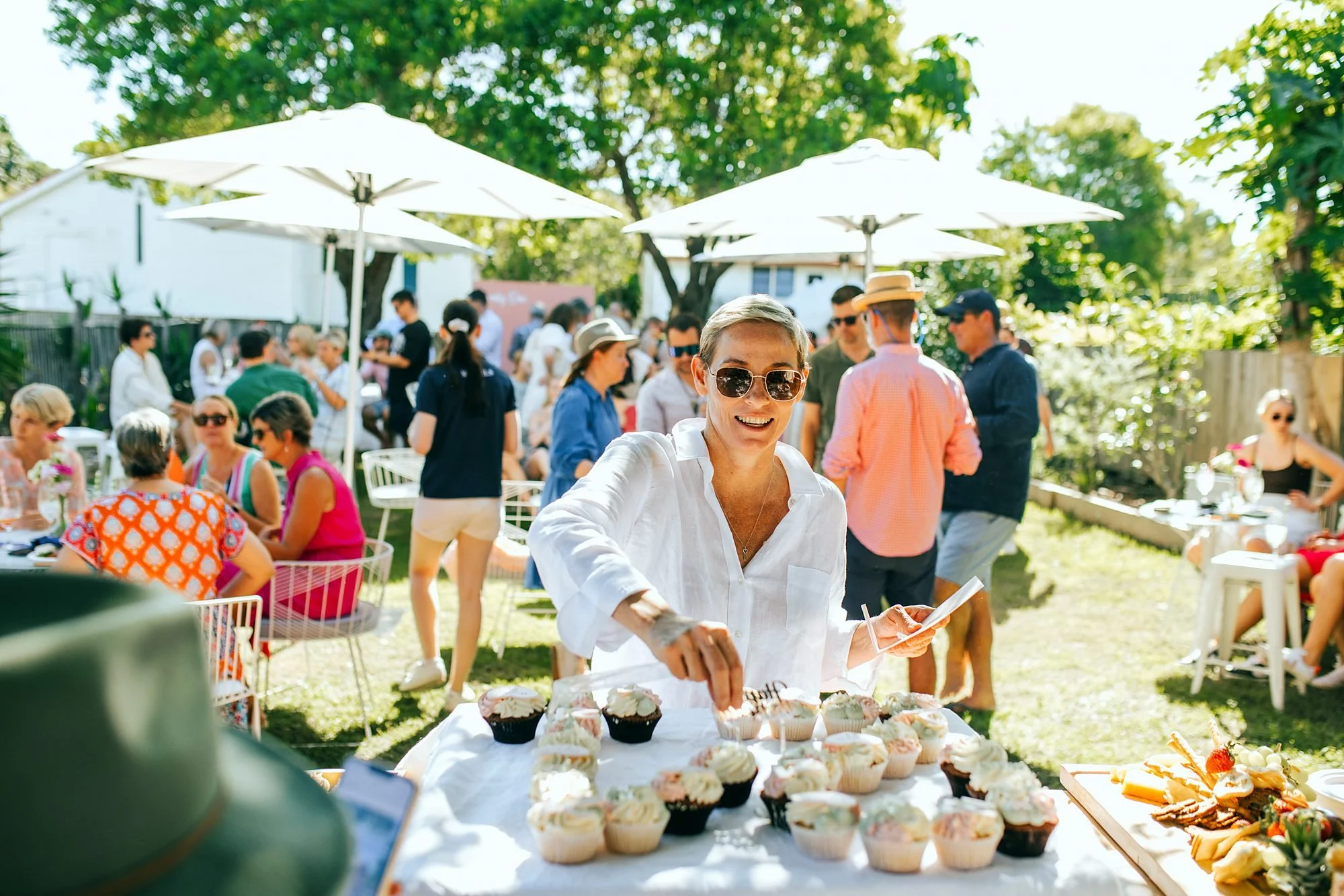 Guest helping herself to desserts at a sunny outdoor garden party