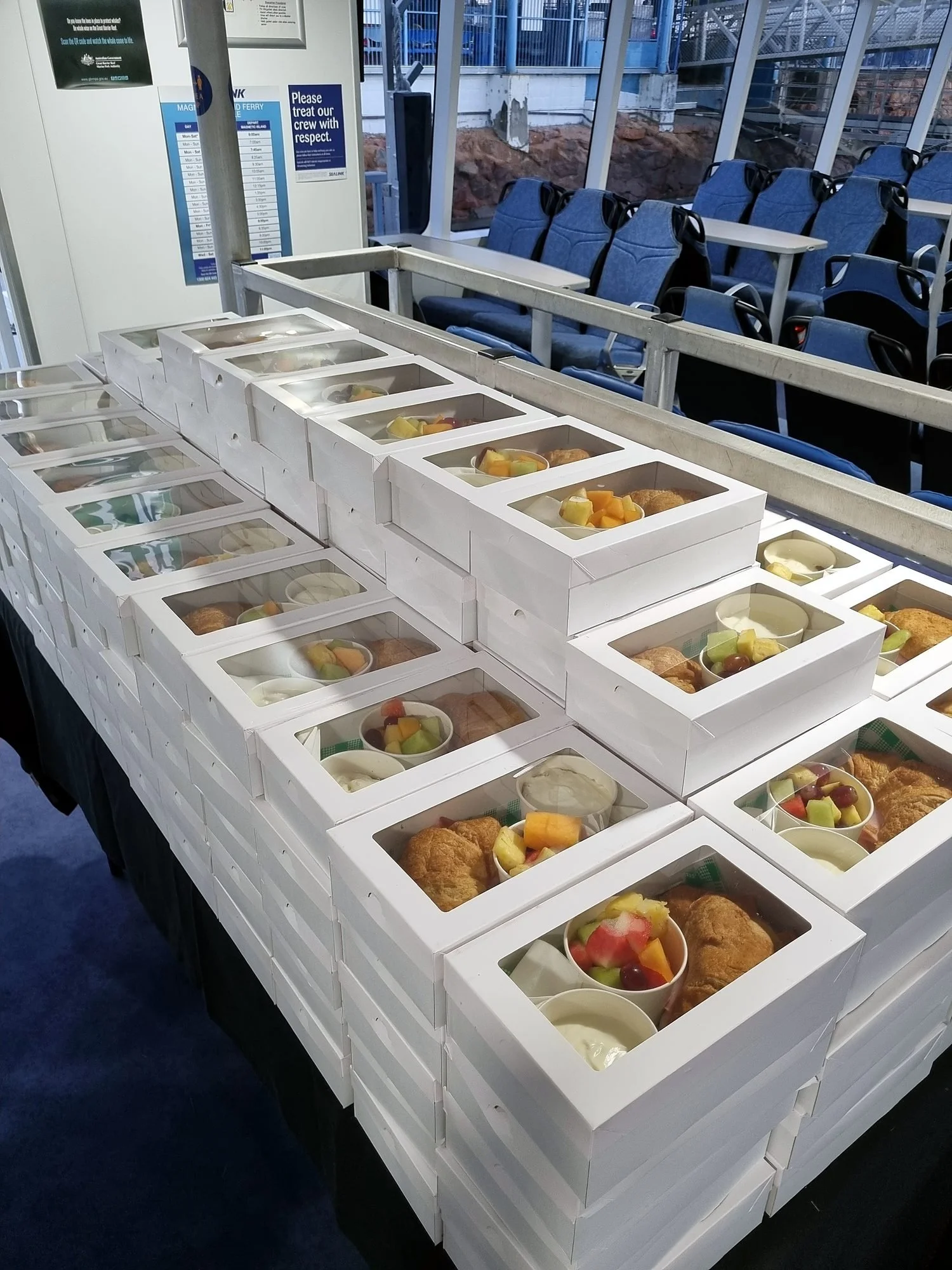 Hundreds of boxed conference lunches lined up in a stadium function room