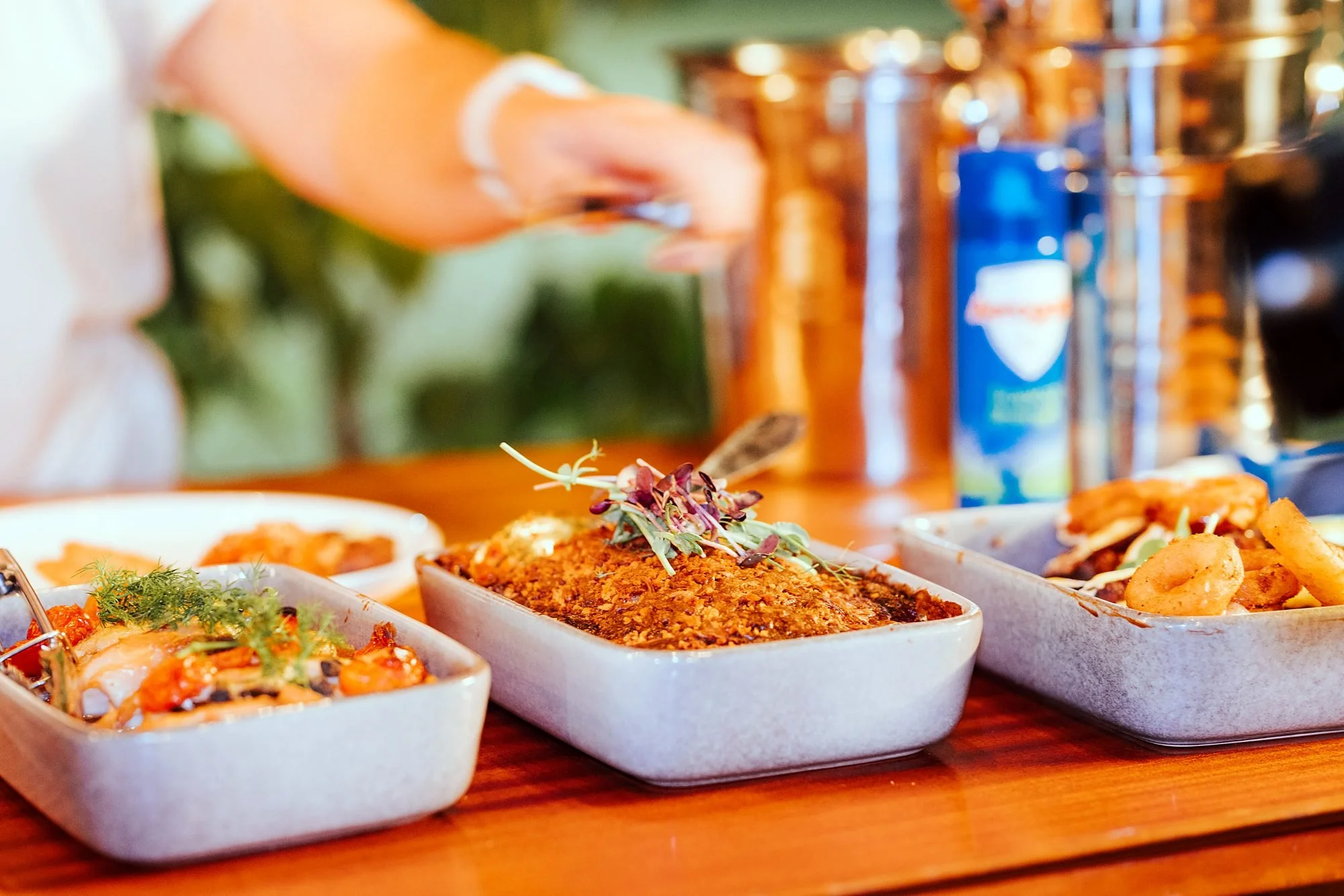 Shared dishes of paella and roast vegetables served down the table