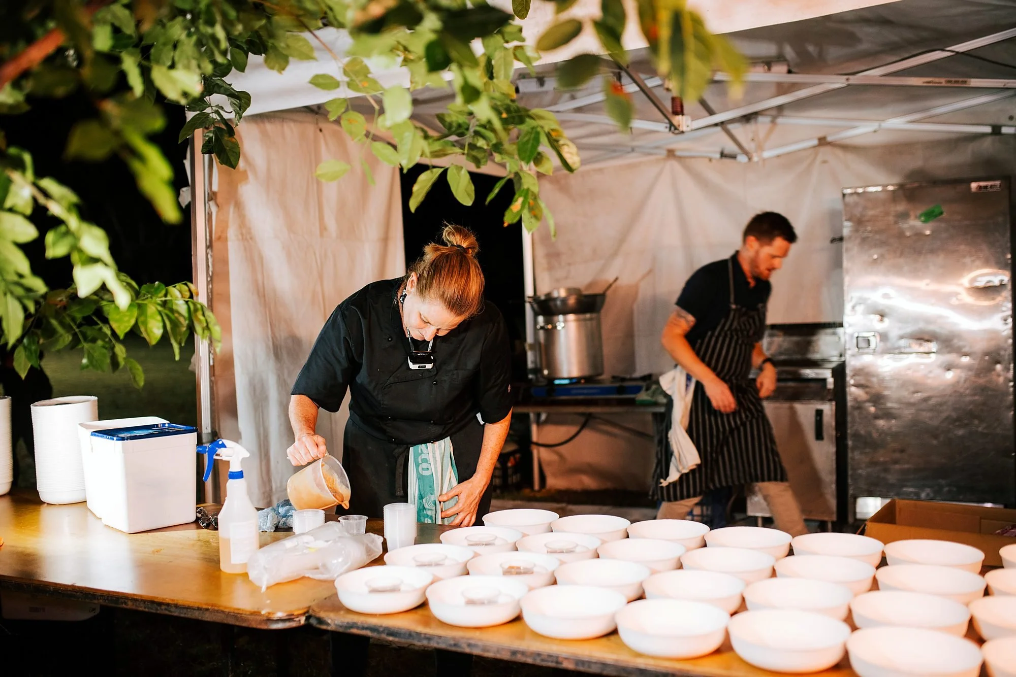 Michels chefs cooking at an outdoor field kitchen station at a night event