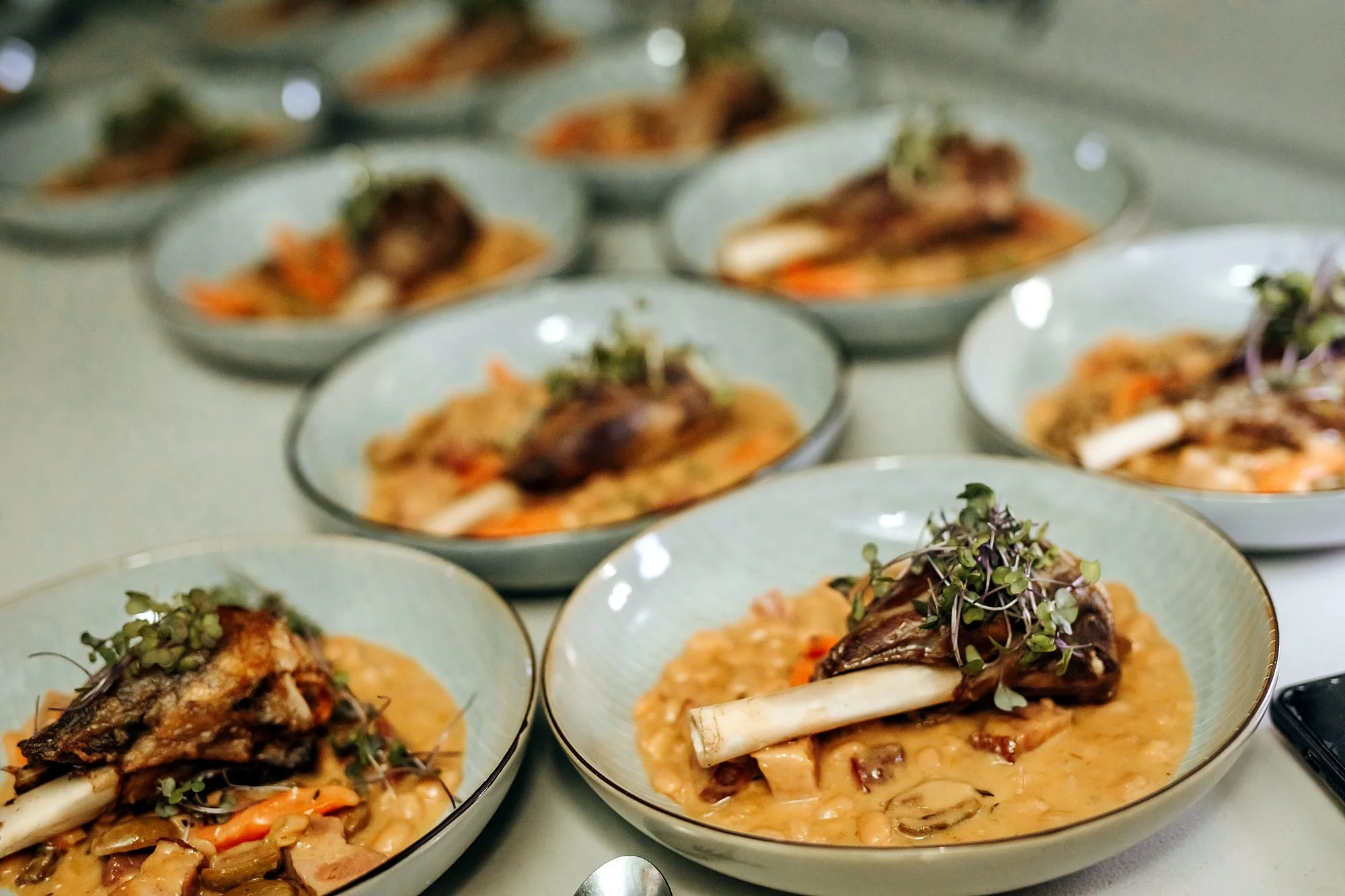 Plated wedding mains of slow-cooked lamb on creamy risotto