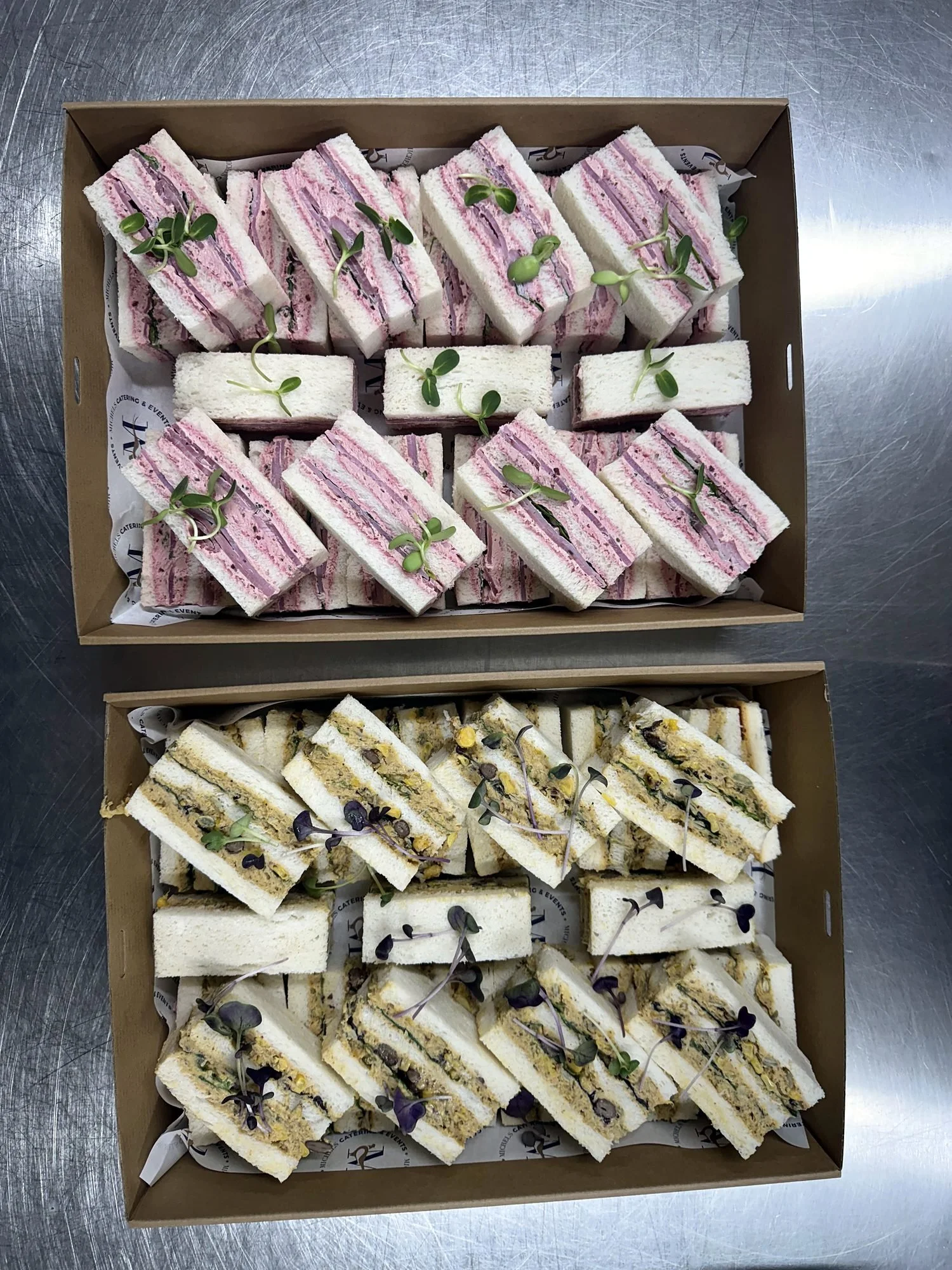Catering boxes of ribbon sandwiches with fresh fillings and micro herbs
