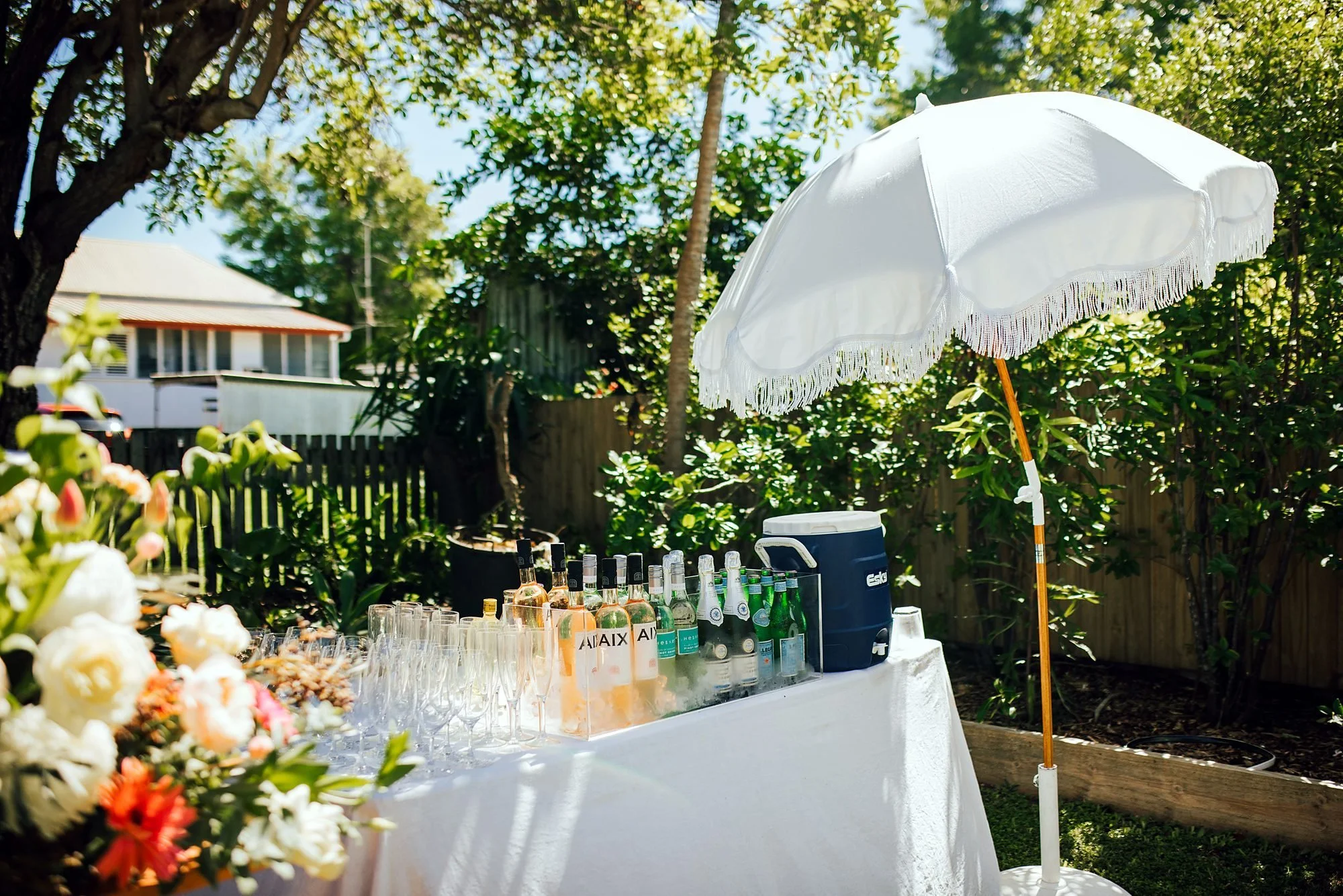 Garden party styled with umbrellas and a welcome drinks table