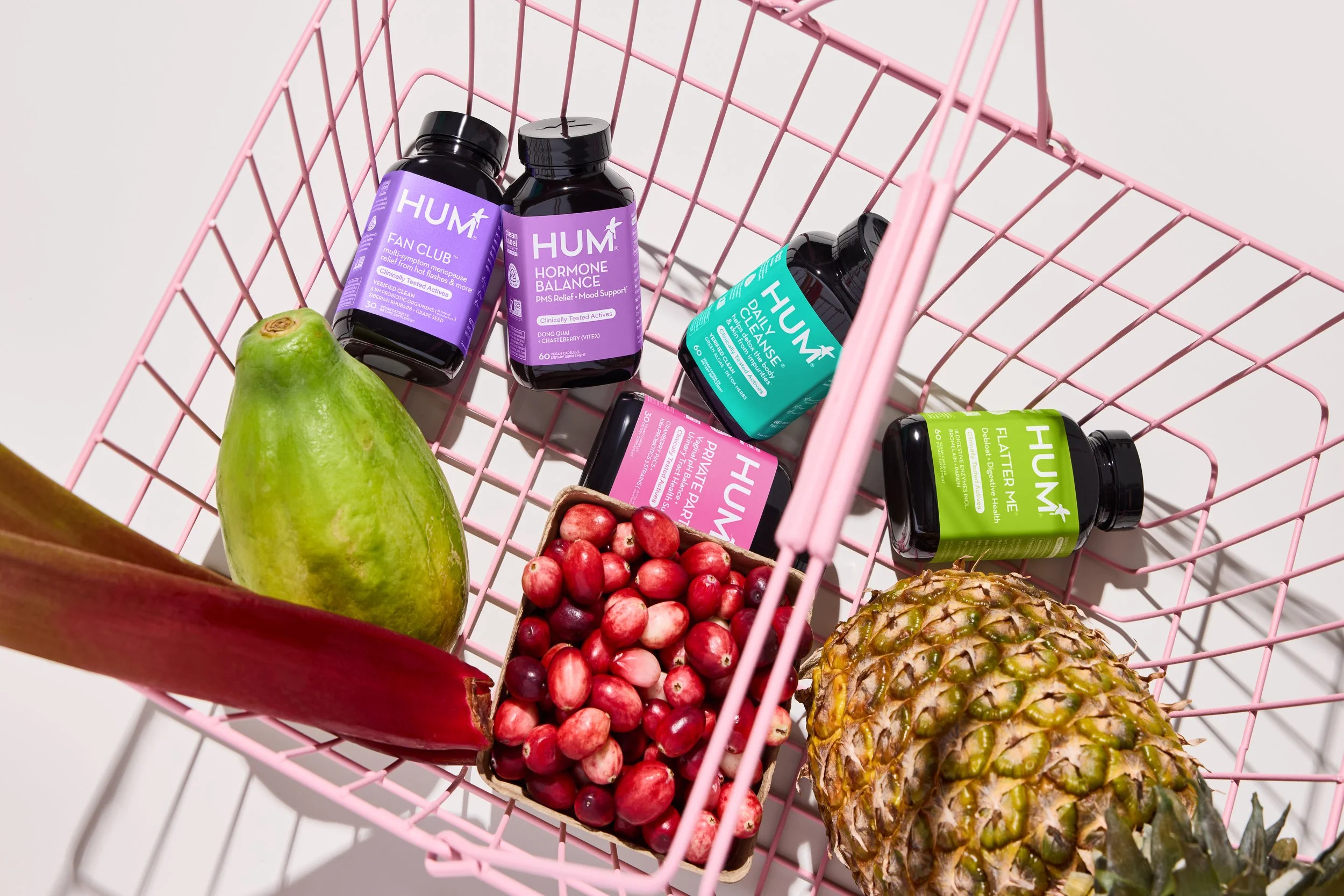 Set designer, prop stylist, product stylist DANA KAPUSTIN handprinted grocery carts featuring Hum Nutrition on a white tiled floor.