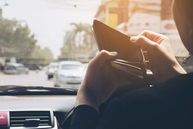man-look-his-empty-wallet-while-driving-car-dangerous-behavior_1150-6348.jpg