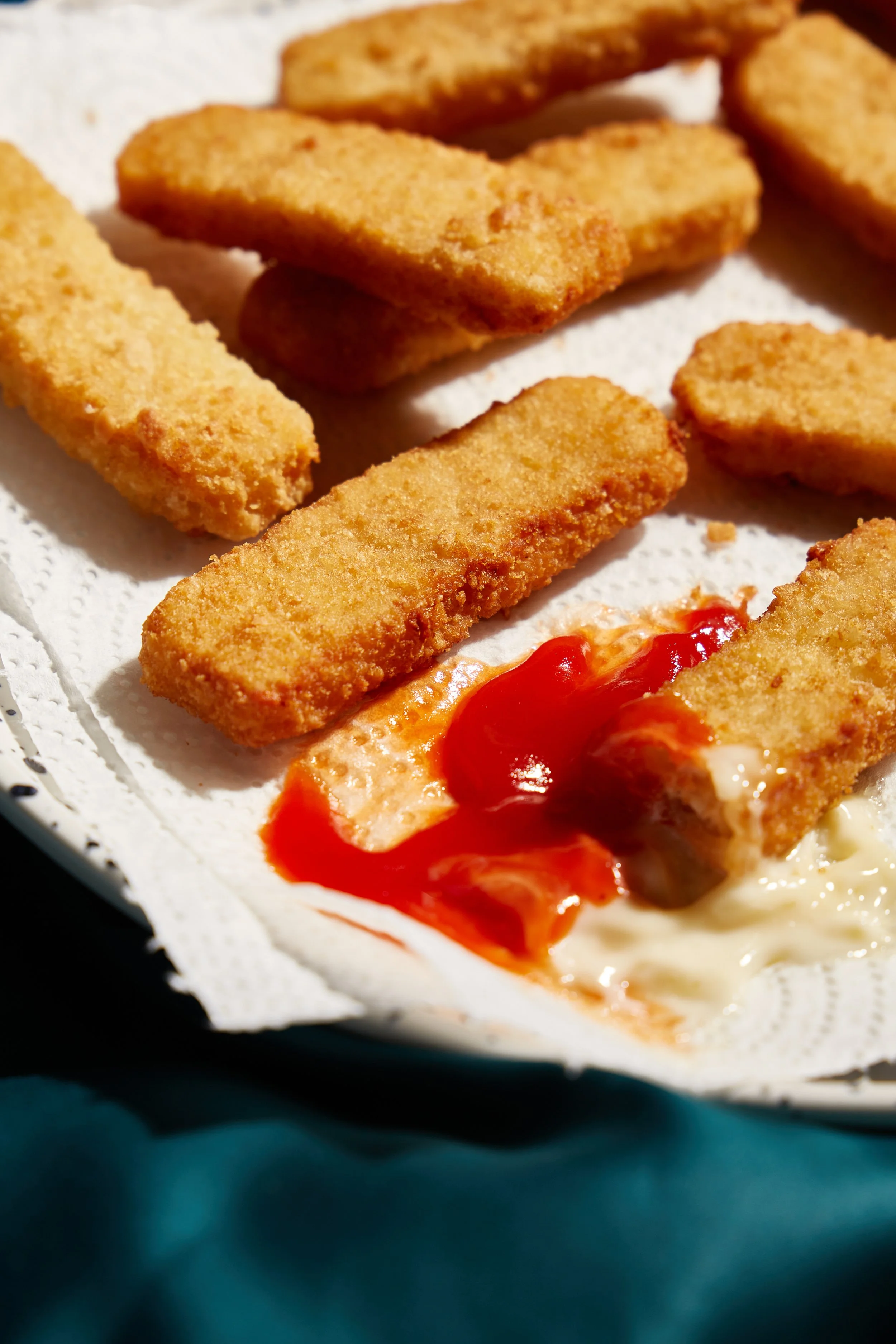 Breaded chicken strips with a side of creamy dipping sauce and ketchup.