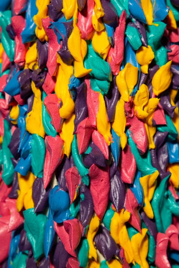 Close-up view of multicolored crumpled paper or material in shades of yellow, pink, purple, and teal.