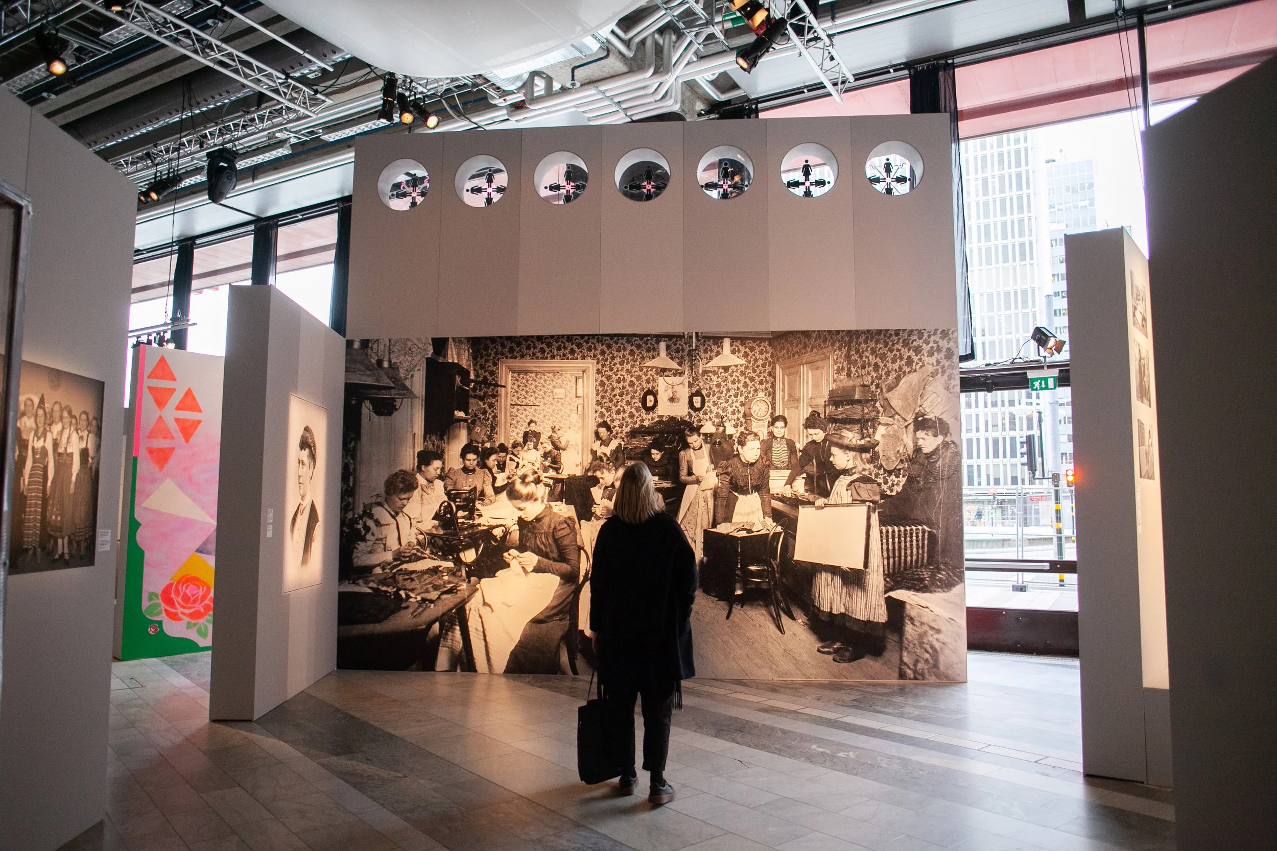 En person står framför en vägg med en arkivbild och tittar upp.