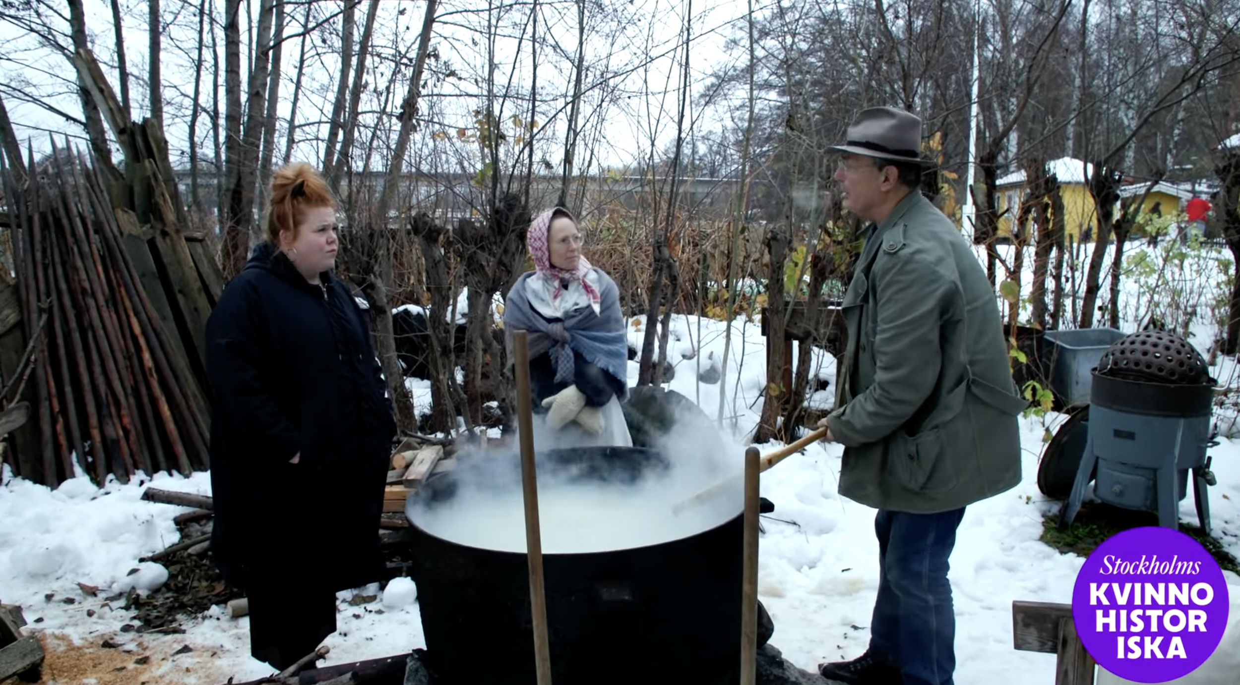 Linnéa Wikblad står en rykande tvättbalja tillsammans med en guide och en tvätterska i sjalett.