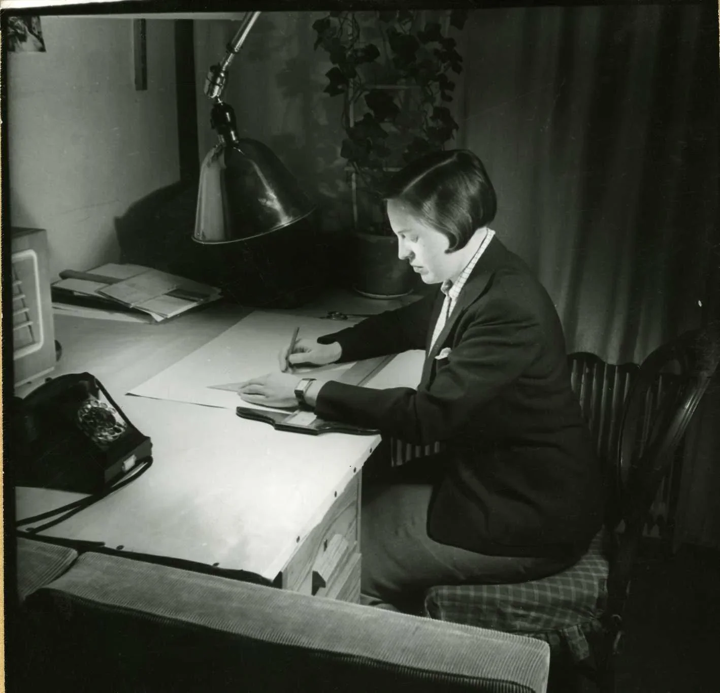 Bibi Lindström sitter vid ett skrivbord och skissar