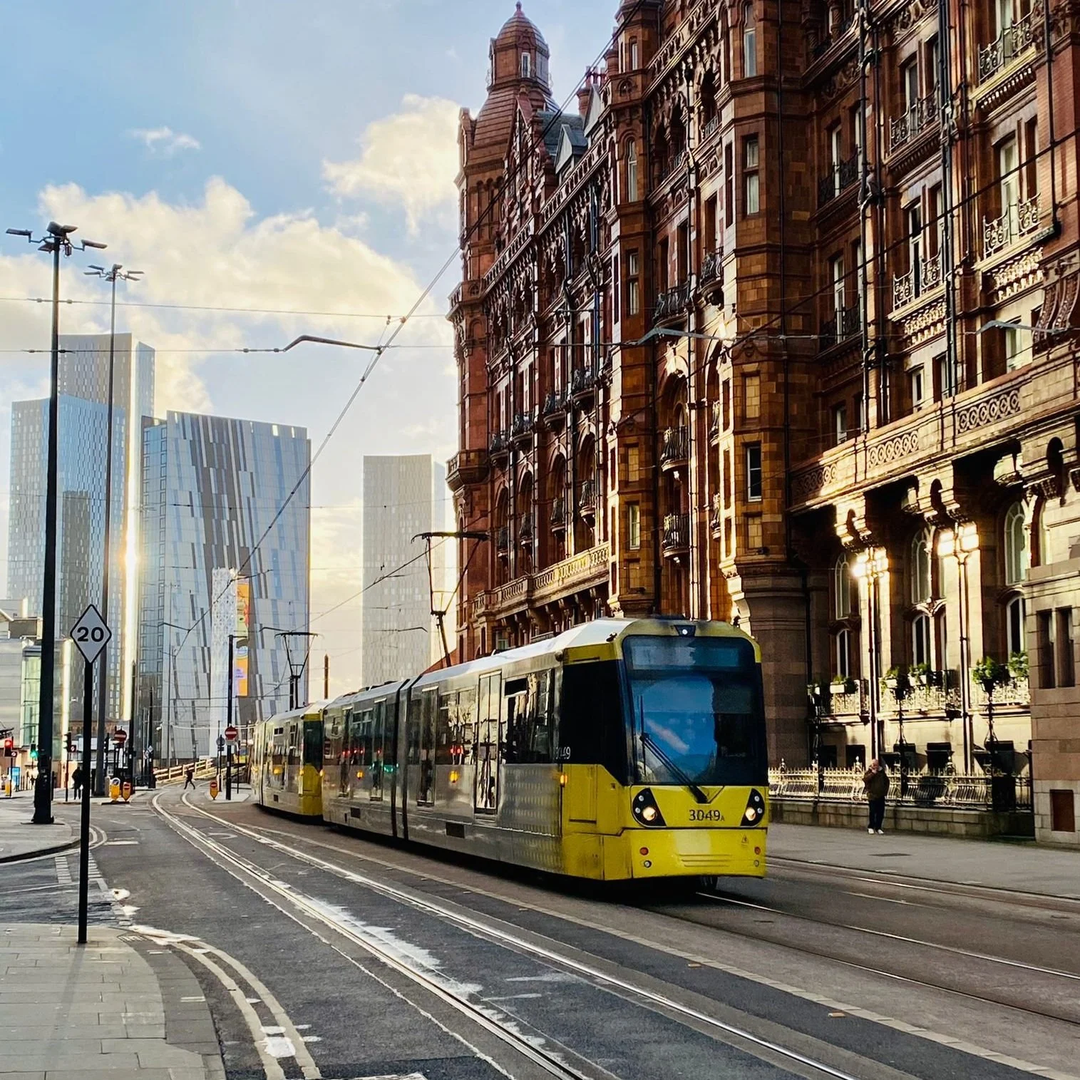 Yellow tram in Manchester city centre with the modern city skyline in the background
