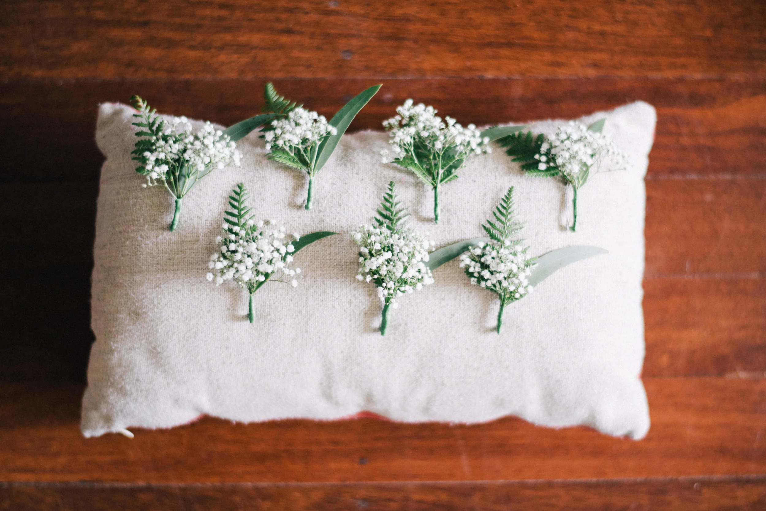 decorative pillow with flower bunches on a wooden surface