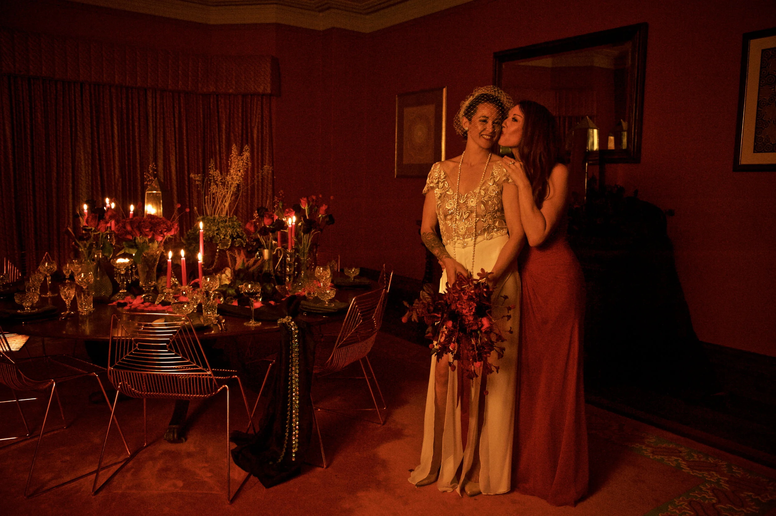 beautiful couple in a red room lit with candles