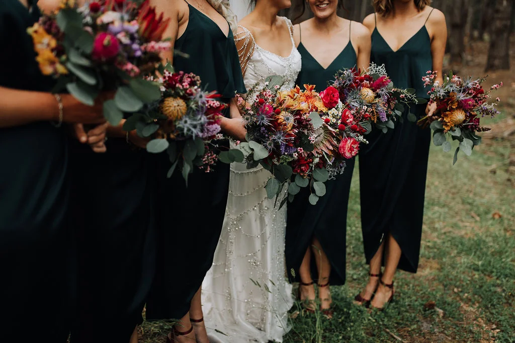 bride and brides maid posing for photo holding flowers