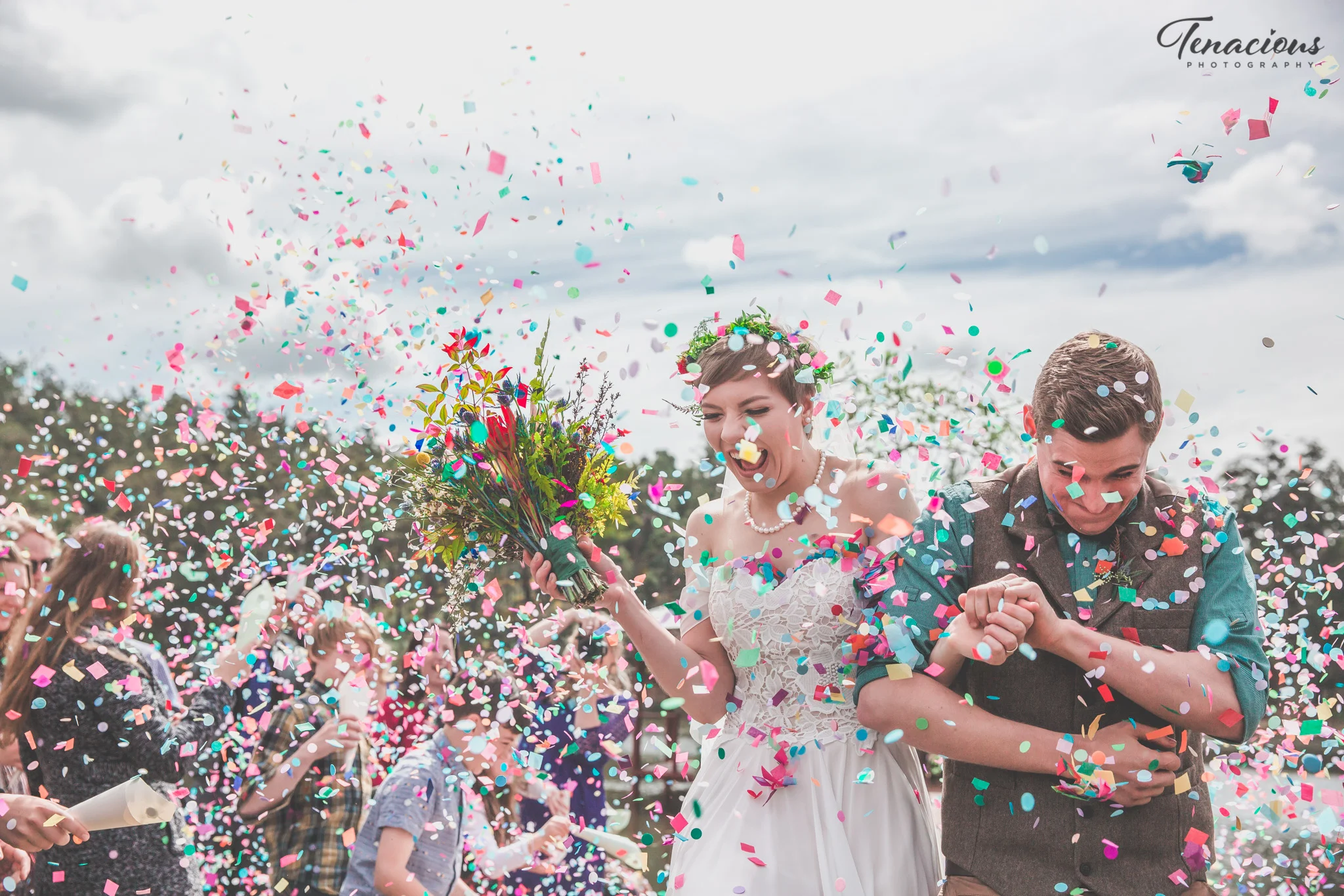 couple walking down the aisle with flowers and confetti