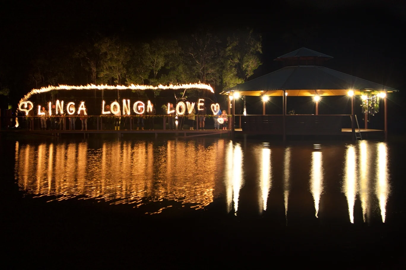 lit sign linga long love at night on the beach front
