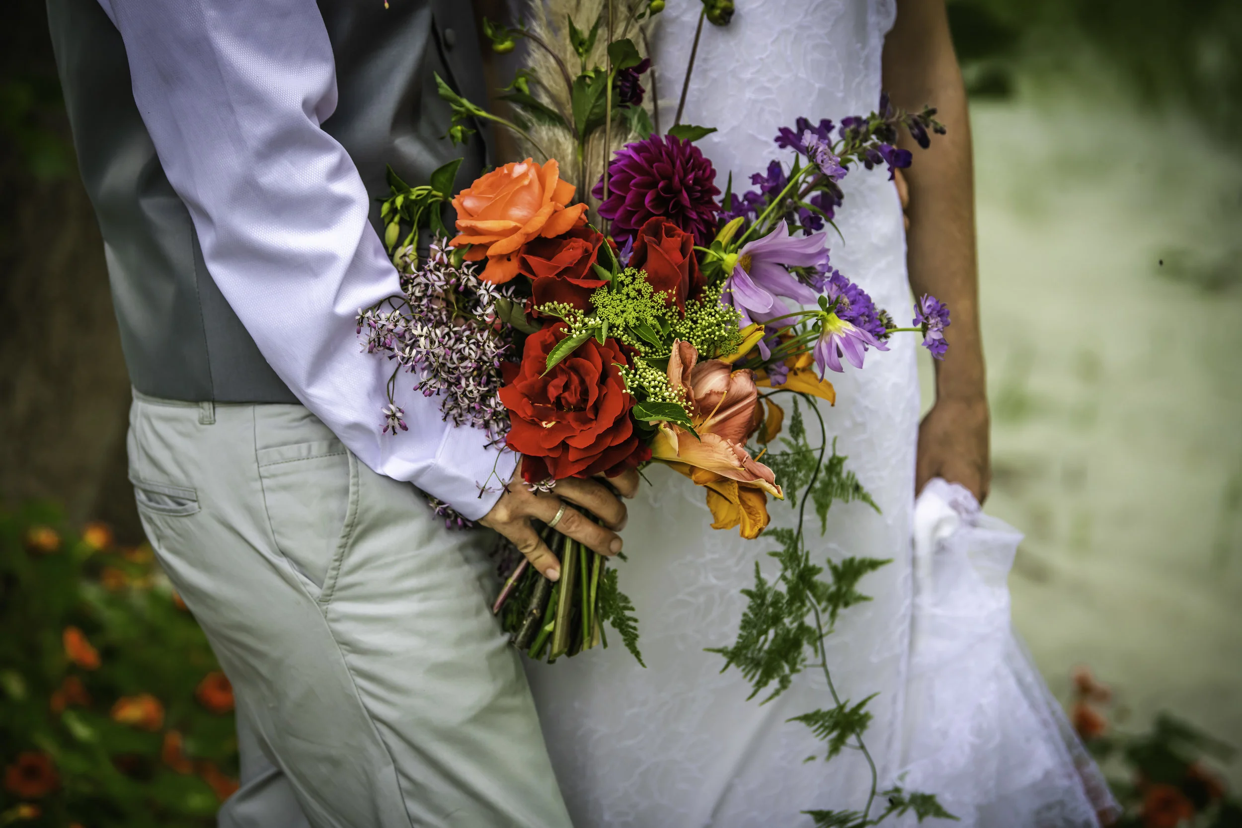 bride and bride groom holding each other with flower bouquet
