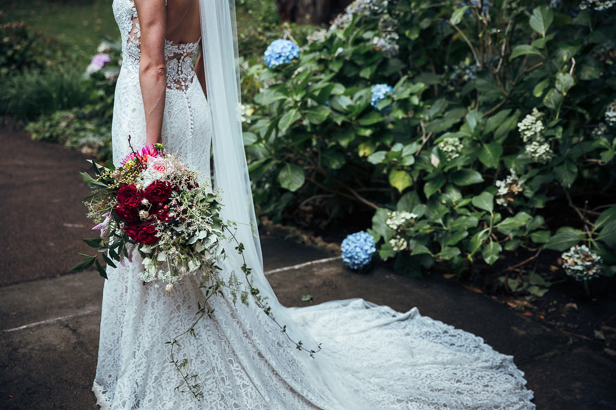 bride holding bouquet flowers alone behind shot