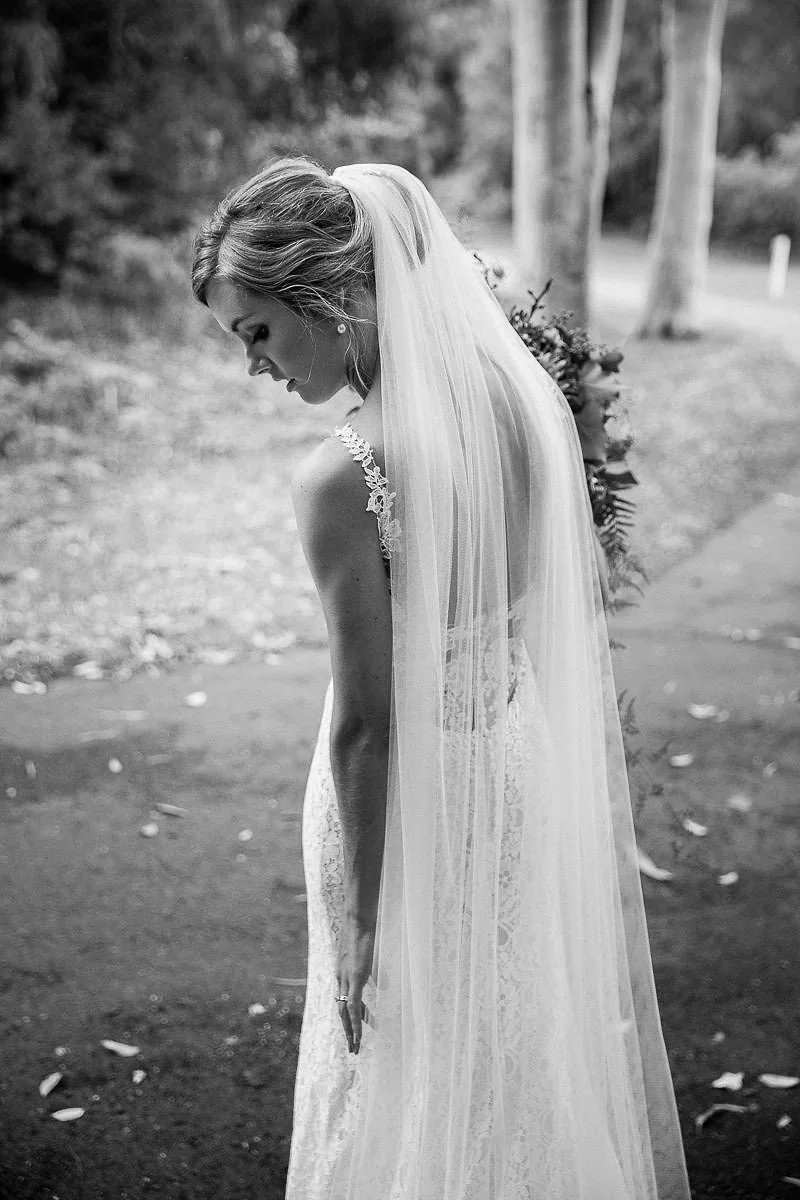 bride holding bouquet flowers alone behind shot black and white