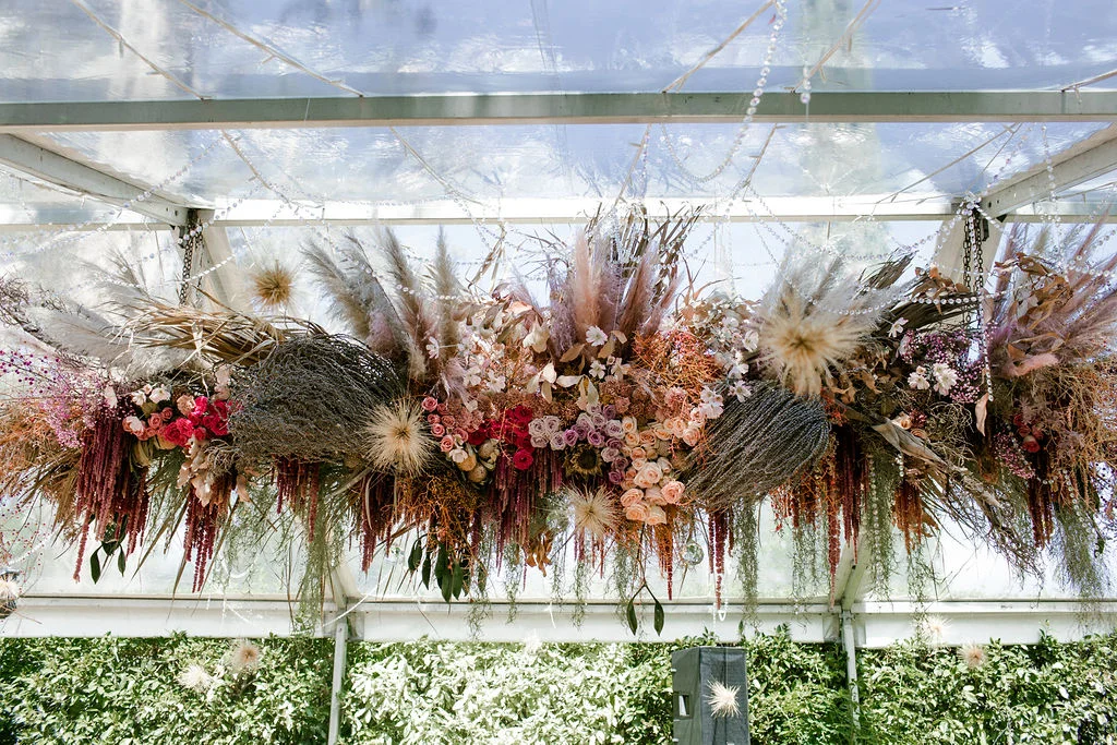 decorative flowers hanging from a glass ceiling