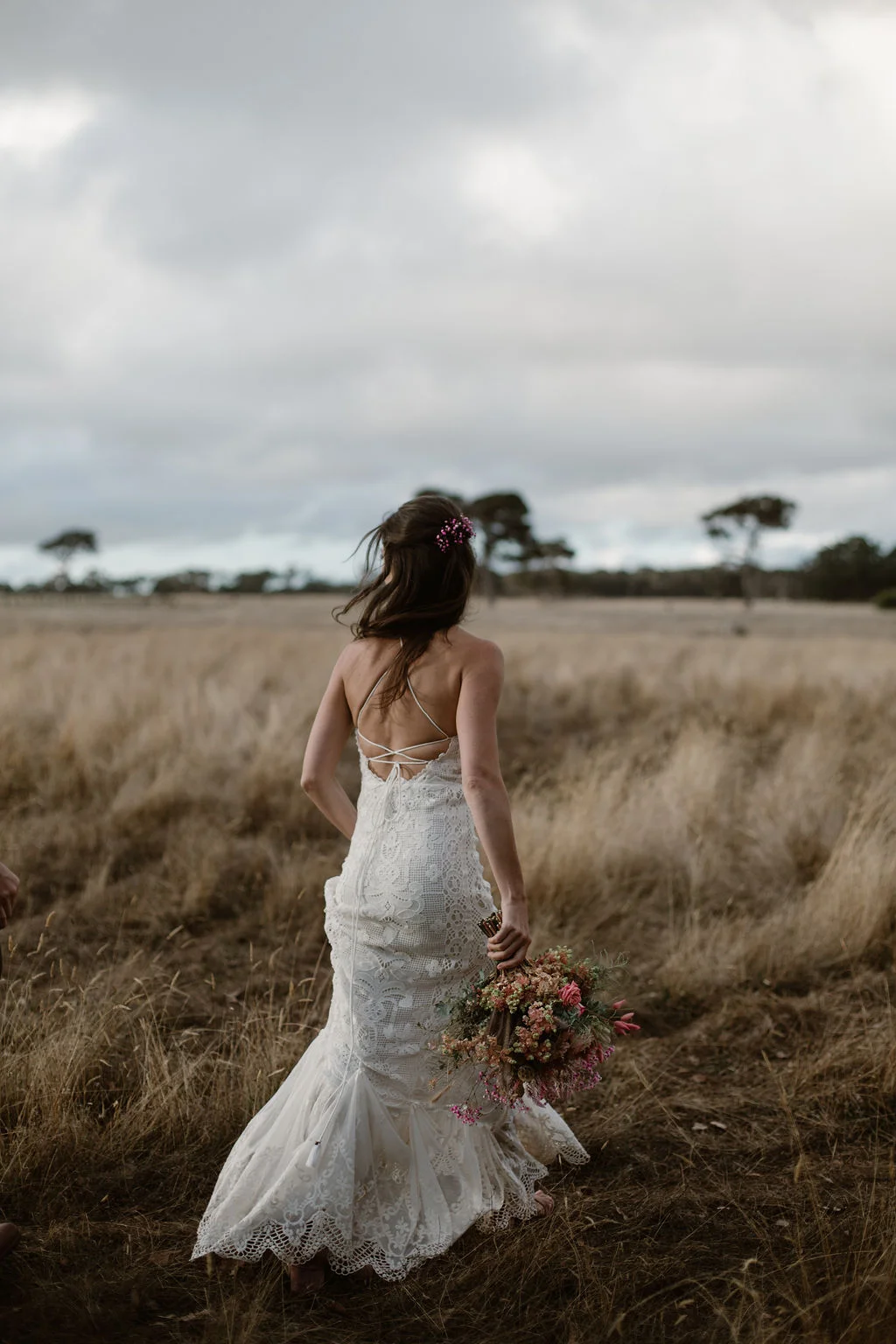 bride walking bouquet of flowers field