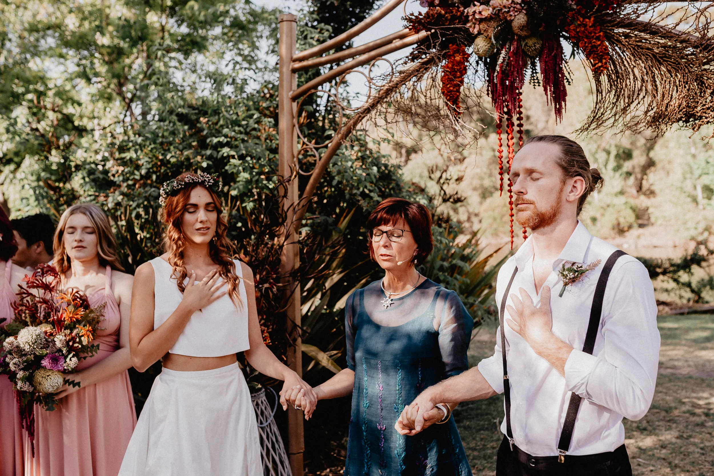 groom and bride taking vows hands on chest emotional moment in the woods