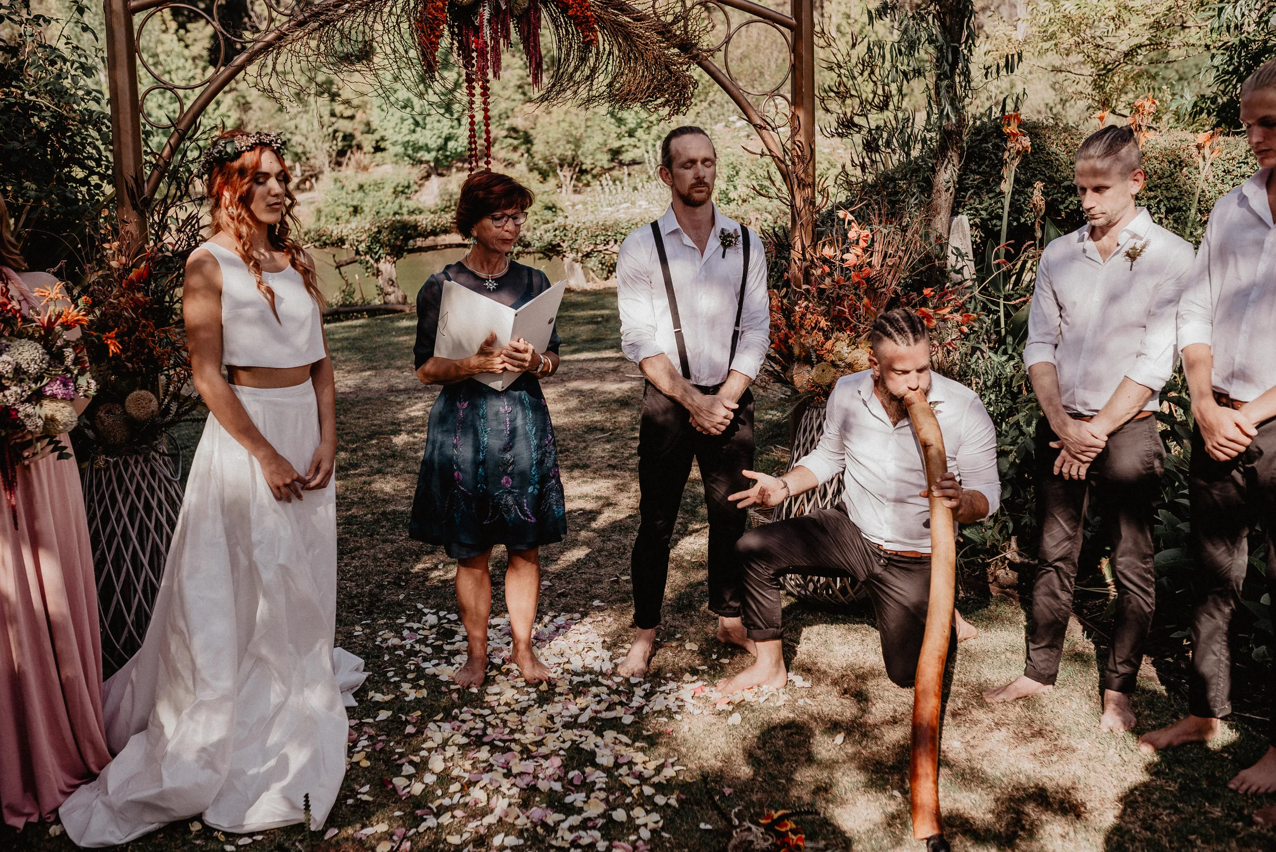 couple taking vows in the woods groom on his knee