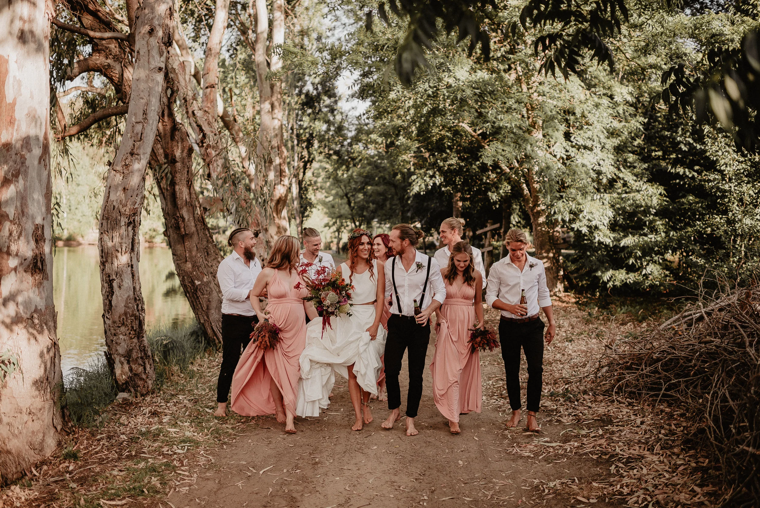 bride and bride groom with best men and brides maids walking