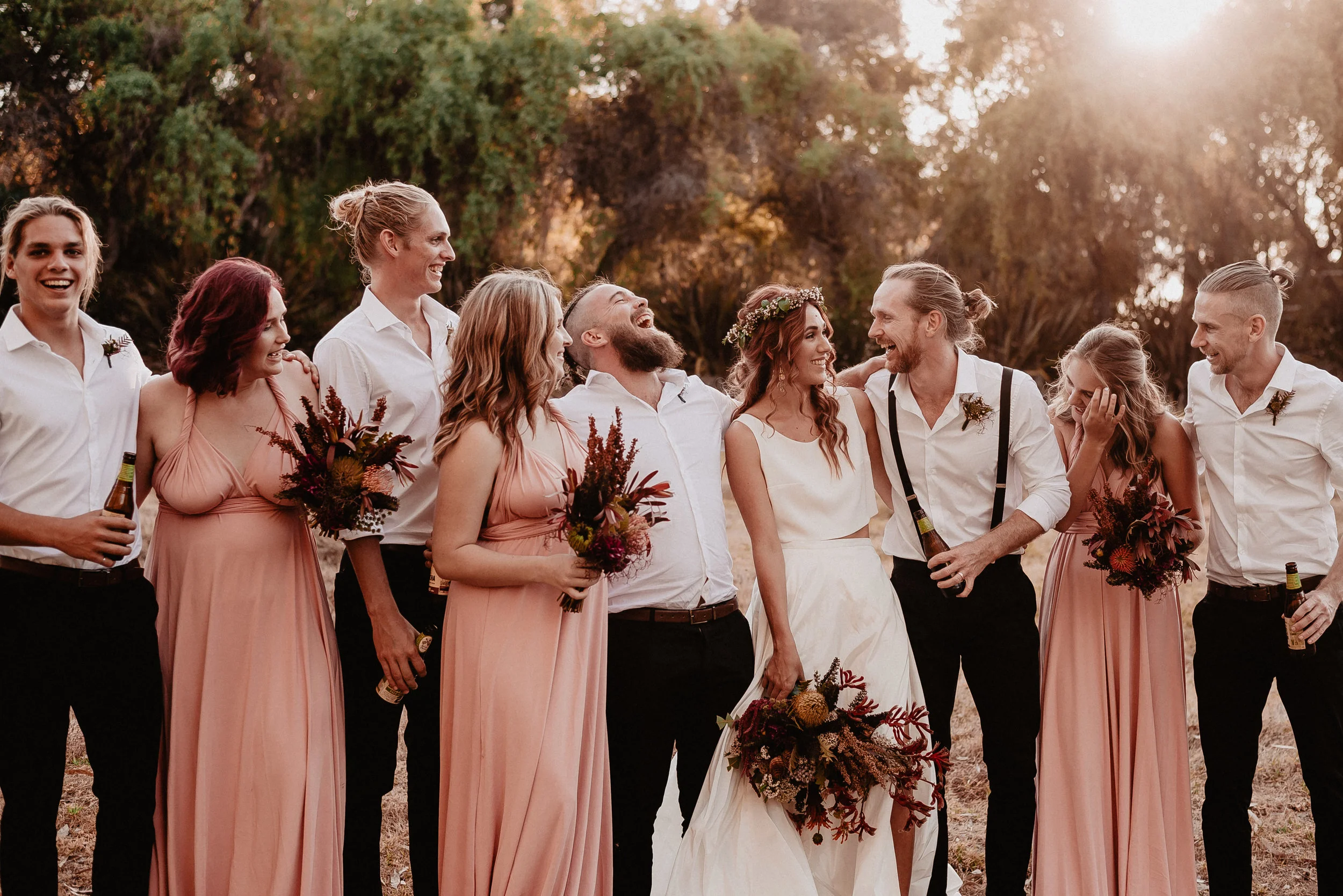 bride and bride groom with best men and brides maids in the field
