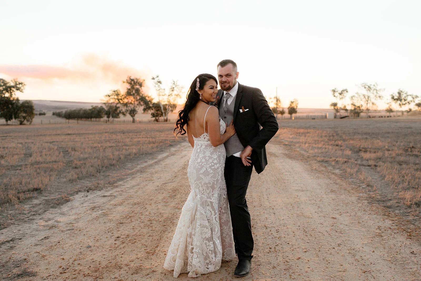 bride and bride groom standing holding each other on the road