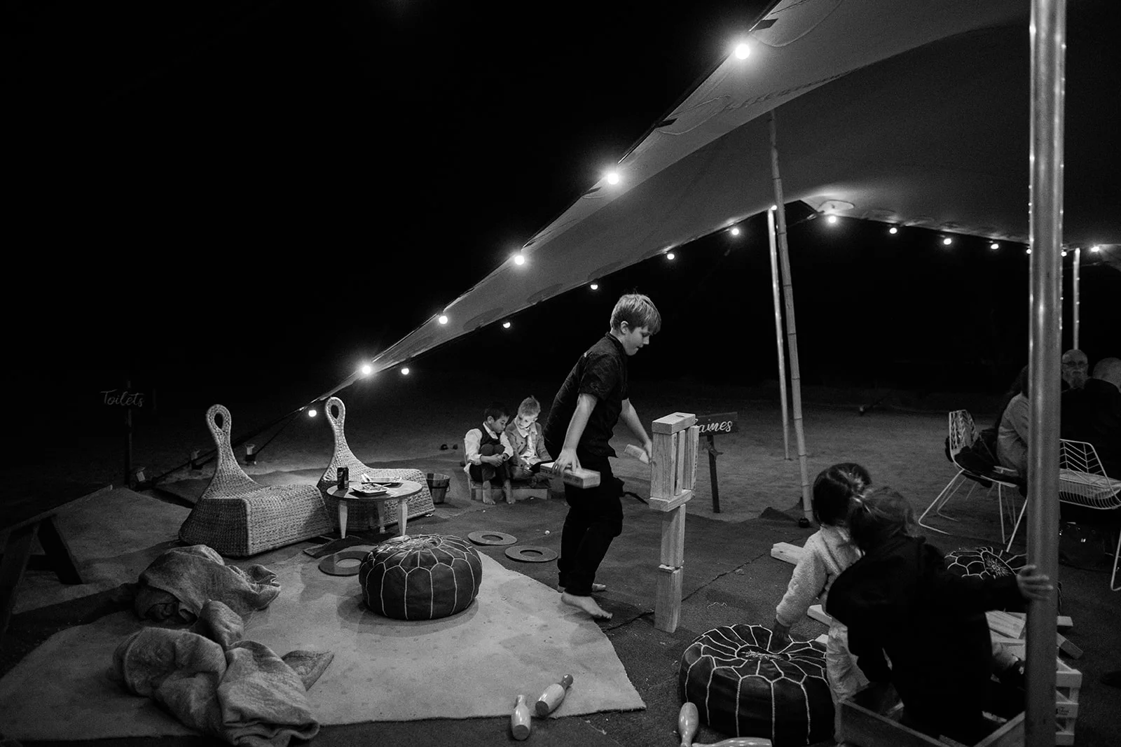 guests playing at night under a tent with lighting