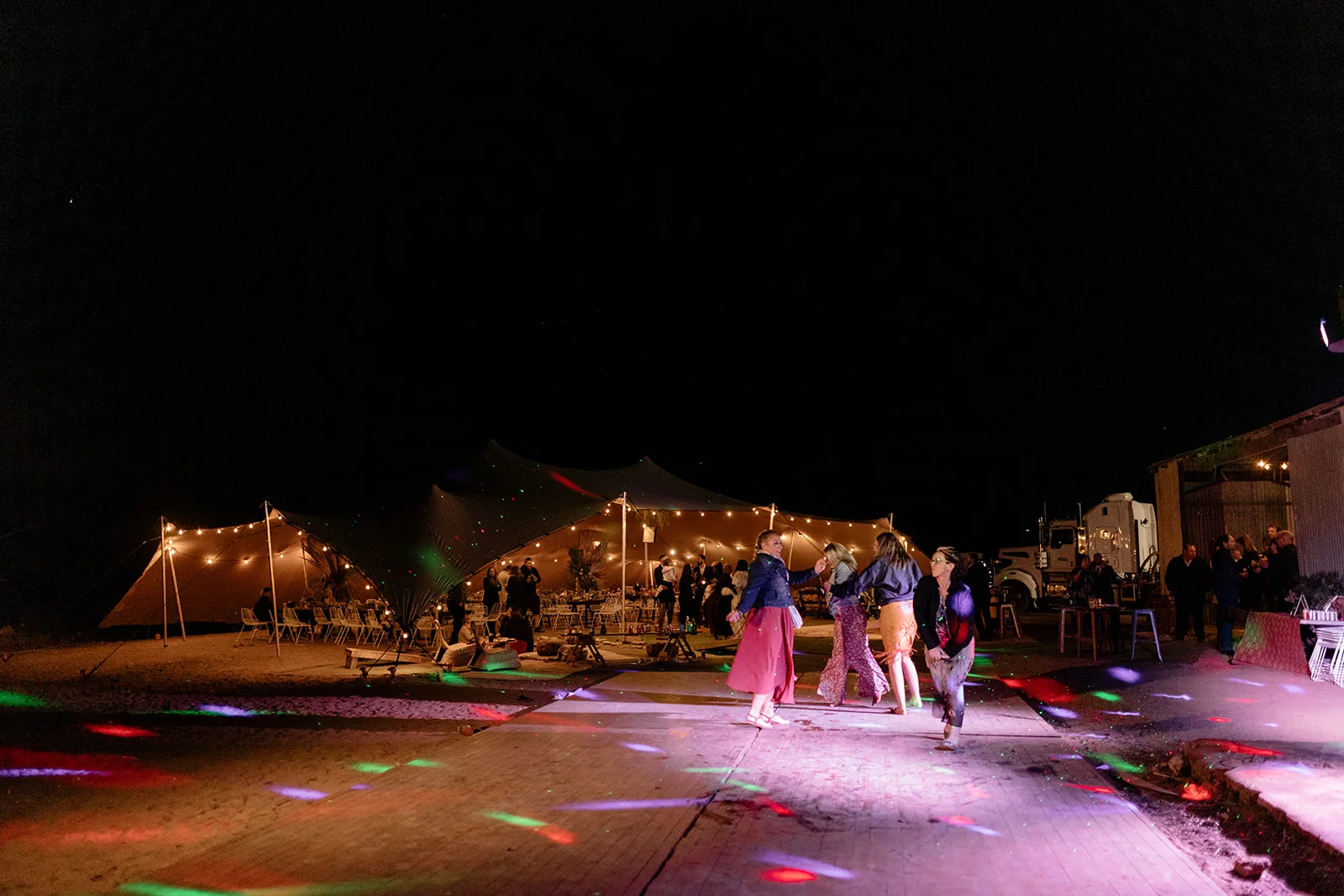 wedding reception at night with guests dancing and beautiful lights