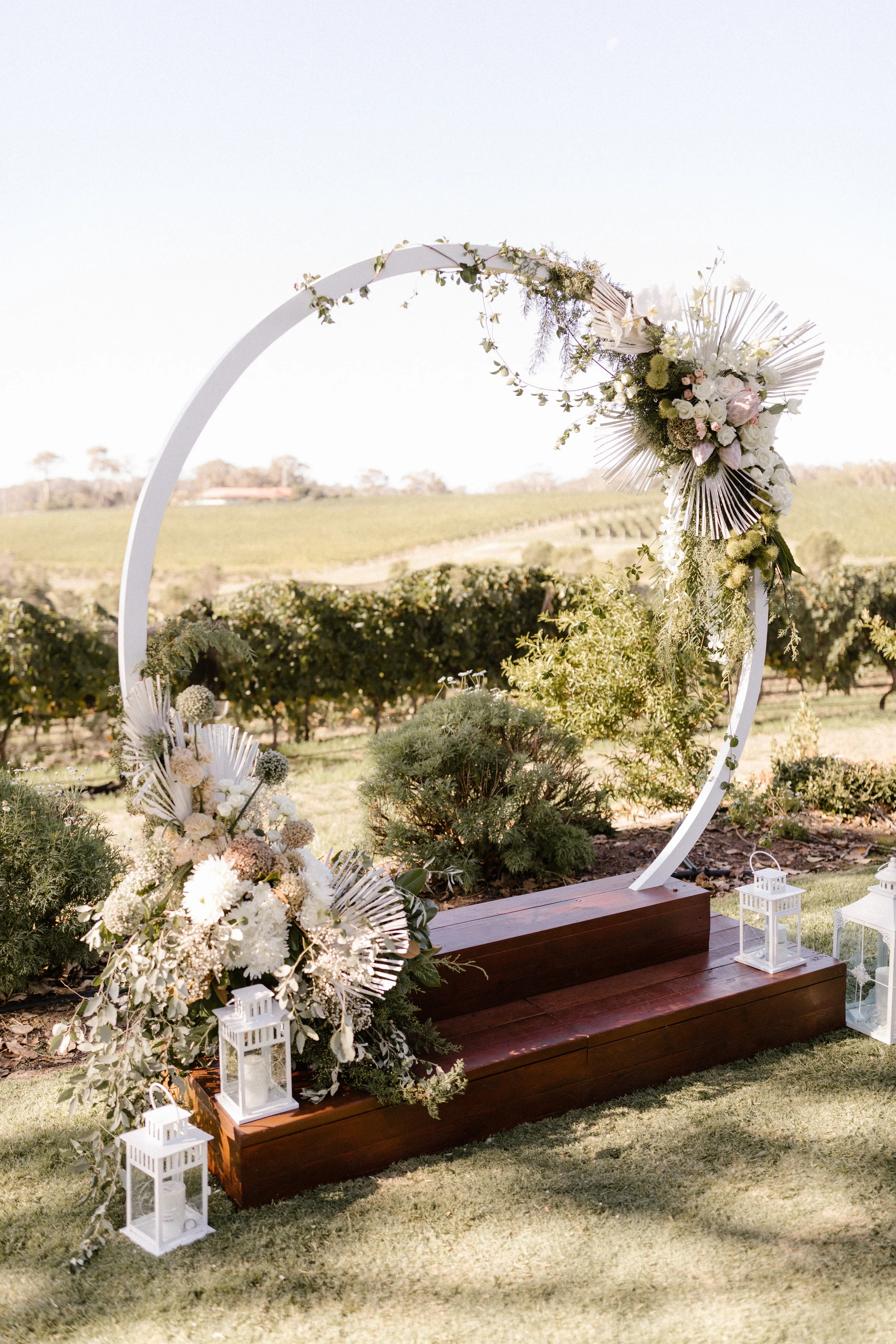  wedding alter with brown wooden podium with wedding flowers hanging 
