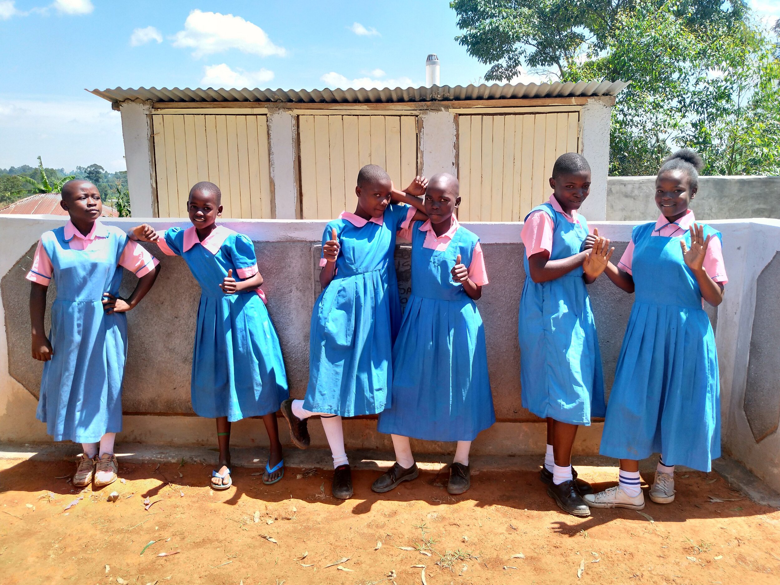 36 kenya19046 Girls pose in front of latrines.jpg