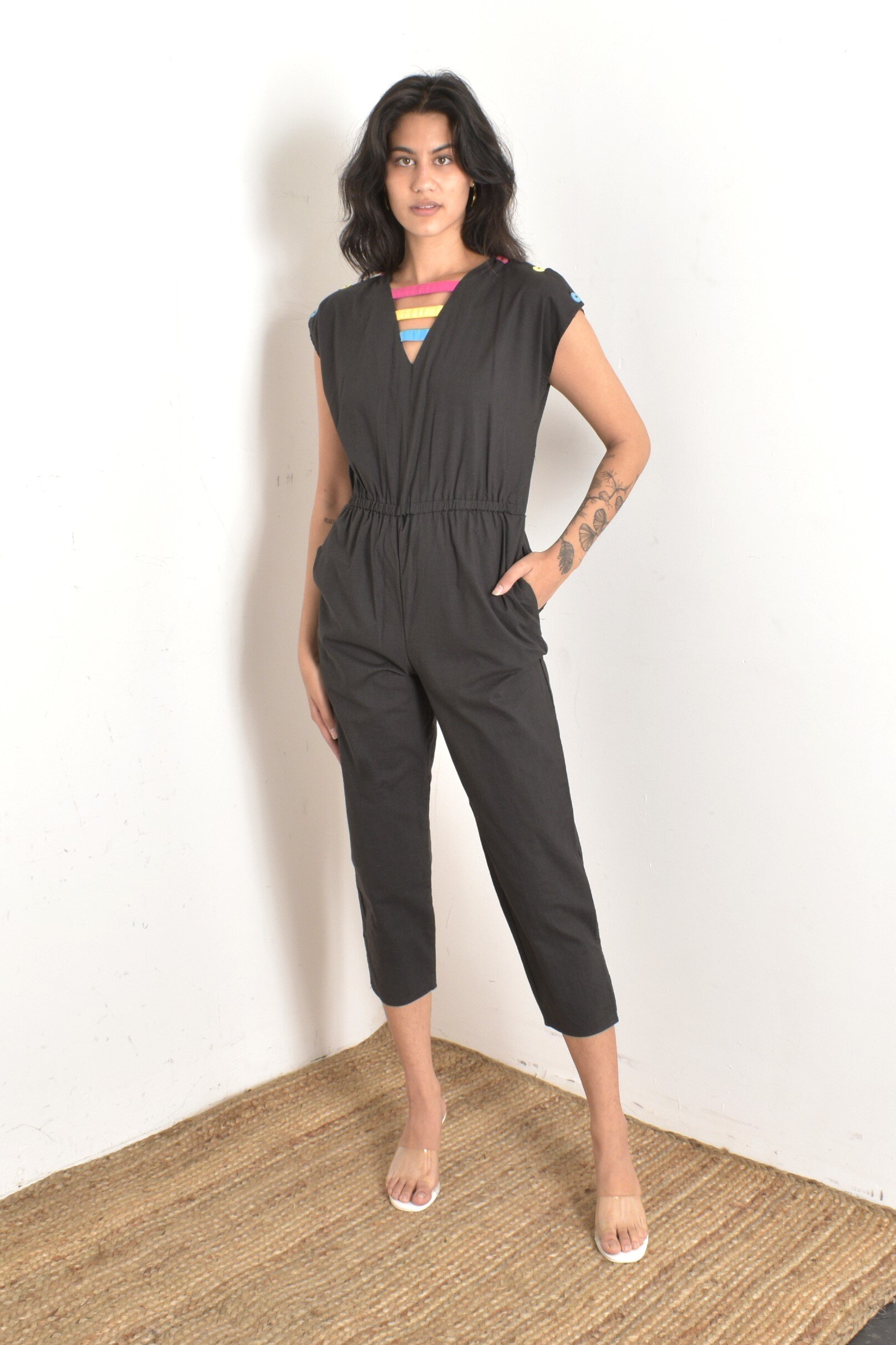 1980s black cotton jumpsuit with button shoulders and colorful accents