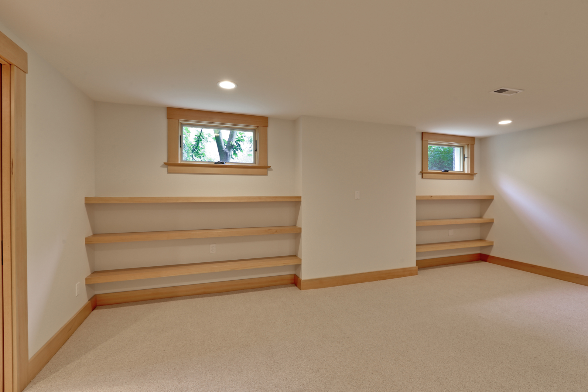  The basement family room was designed to add flexible and highly functional space to the house. The floating shelves will eventually house games, toys, and books for our clients' growing family. 