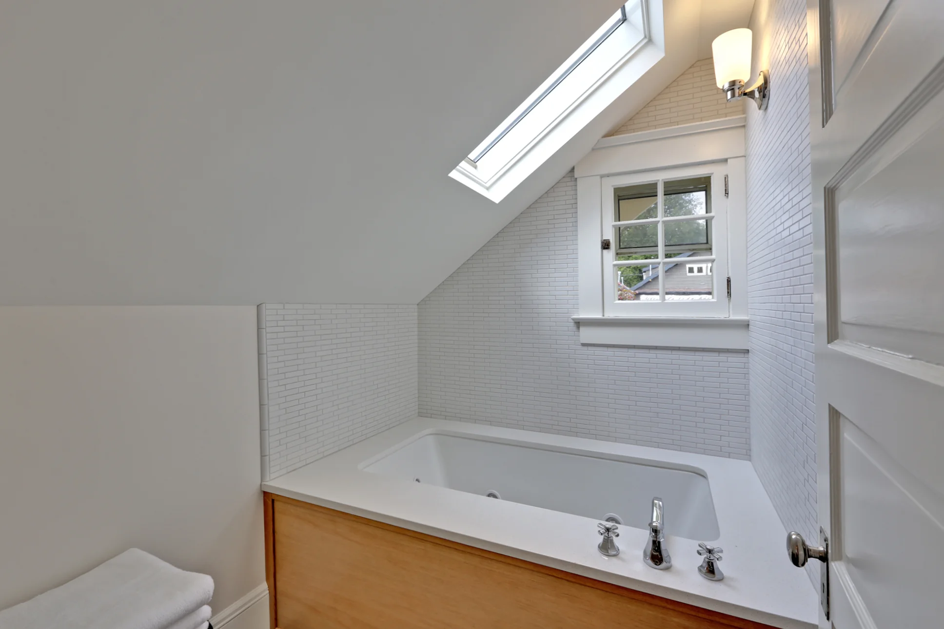 This modern tub with CaeserStone deck tucks into the eaves of the house just perfectly, creating a private oasis for the homeowners. Out of the frame. we snuck some storage space under the sink with custom drawers cut around the plumbing fixtures.