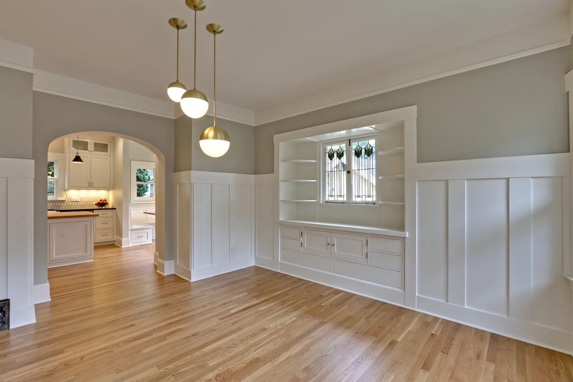 We redesigned the passageway from the dining room into the kitchen for better flow and to match the arches found elsewhere in the home. Fun light fixtures from Rejuvenation compliment the revitalized original cabinets and wainscoting; blending old and new really works on projects like this.