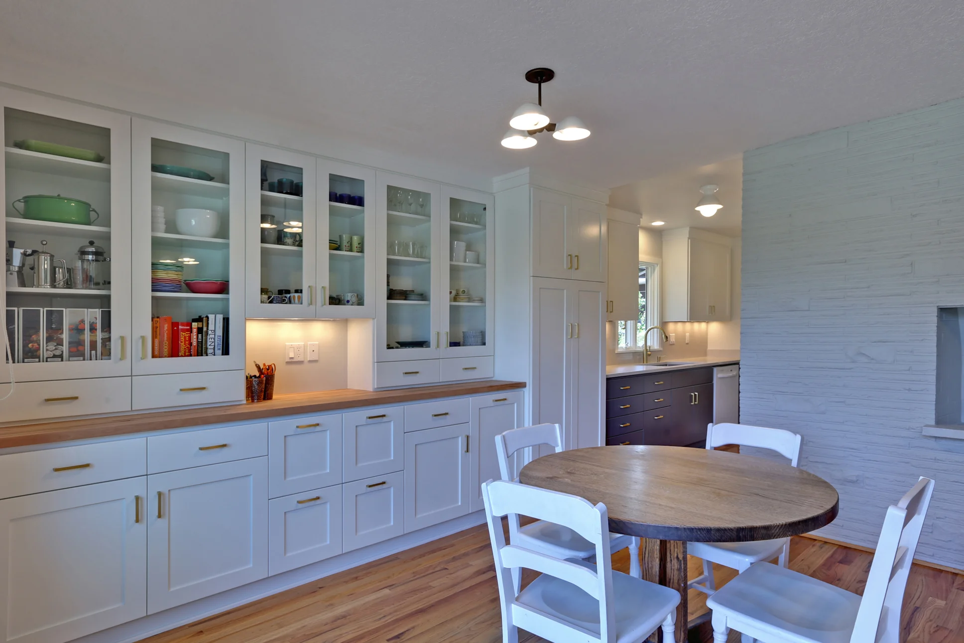 This kitchen ties seamlessly into the adjacent family room, with a tall pantry cabinet in the center of the wall to define and delineate the two spaces.
