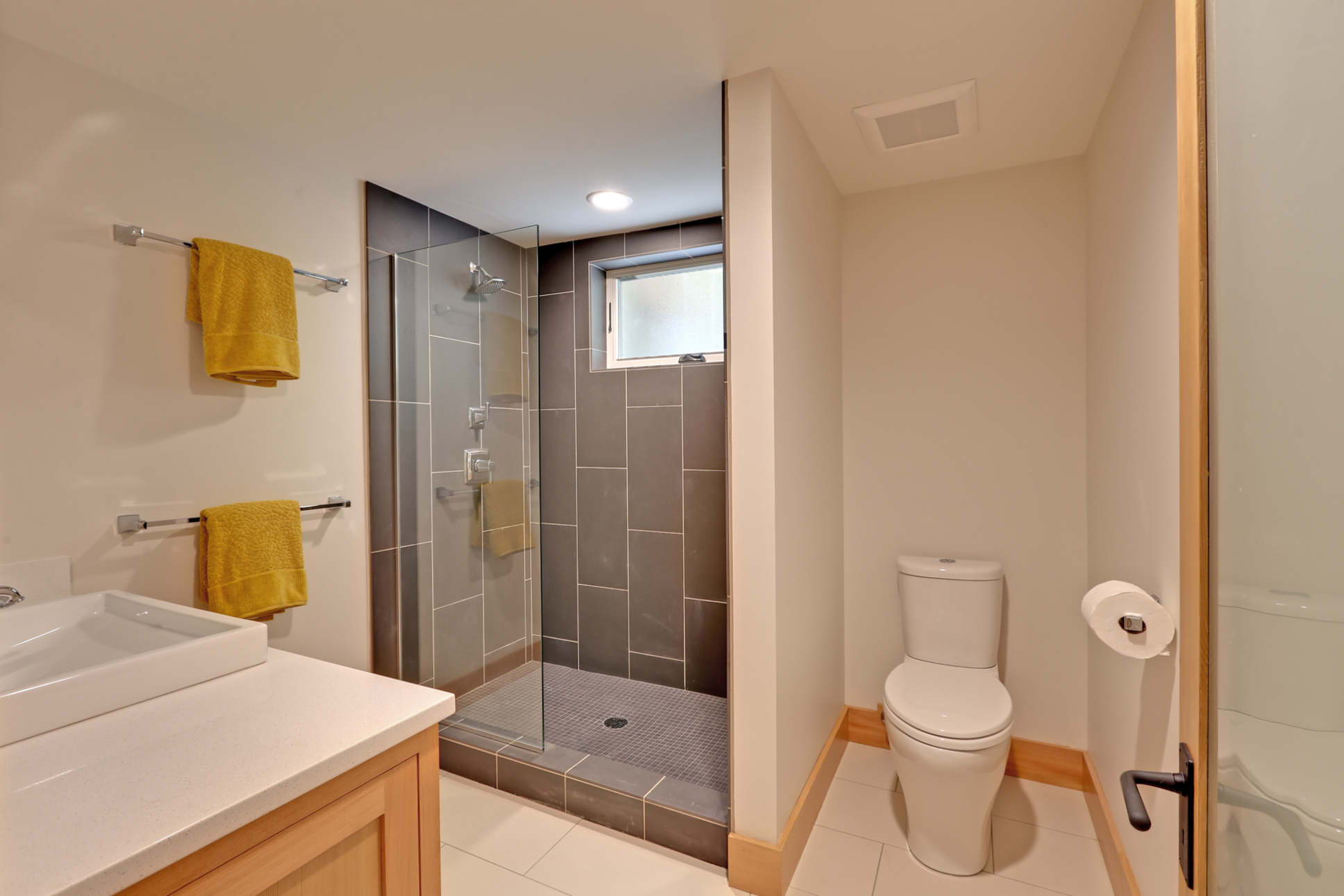  In the basement, we added a light and airy modern bathroom. Large tiles from Daltile and simple fir trim and cabinets really elevate the space. 