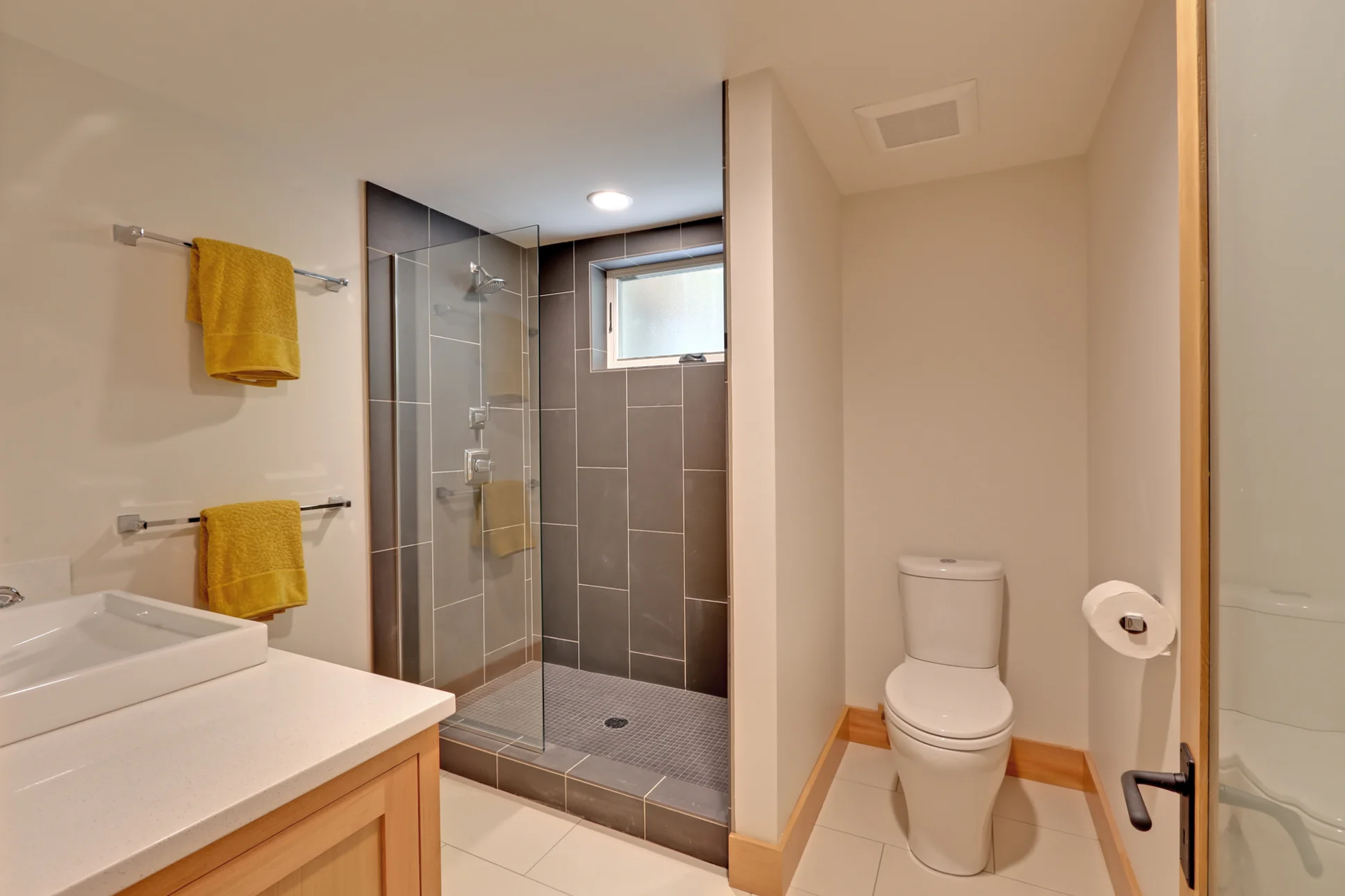 In the basement, we added a light and airy modern bathroom. Large tiles from Daltile and simple fir trim and cabinets really elevate the space.