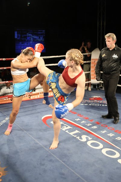Coach Casey landing a strong middle kick during one of her professional fights.