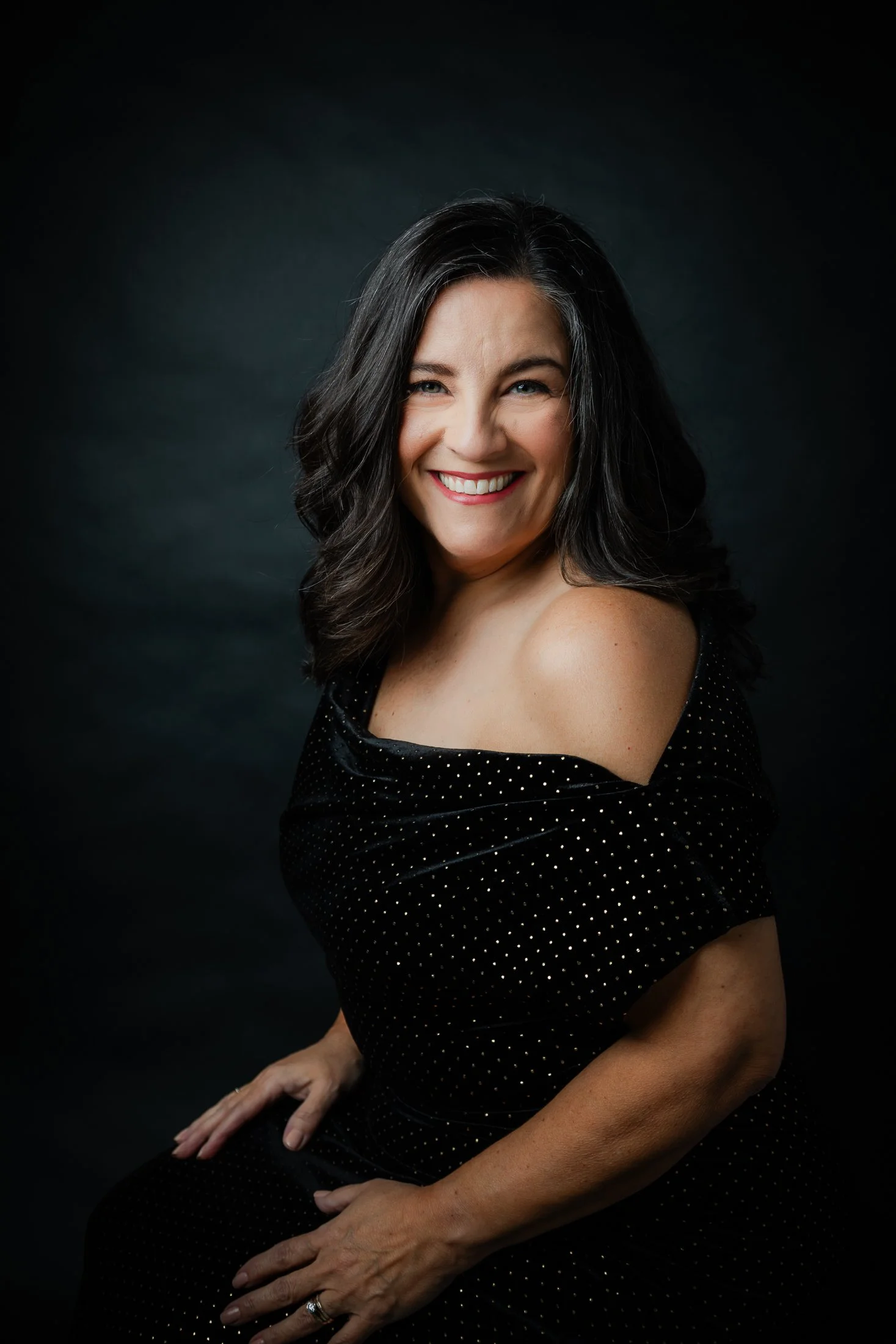 Studio Portrait of a woman over 50 wearing a black evening gown in a sitting pose by Amanda Faucett Photography in Houston, TX