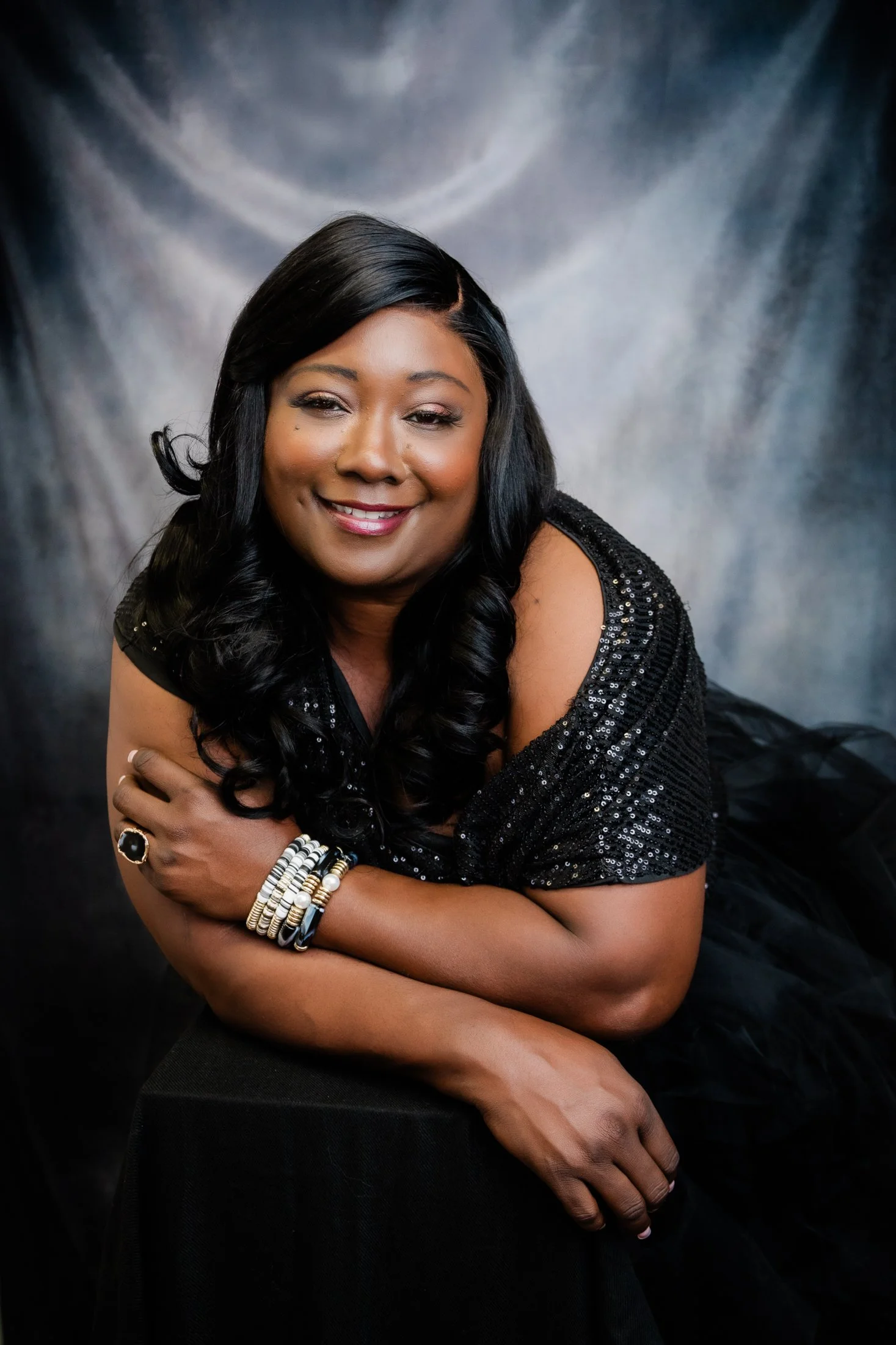 Timeless studio portrait of Catina, a gorgeous black woman wearing a tulle skirt and black sequin top, celebrating beauty and confidence after 50.