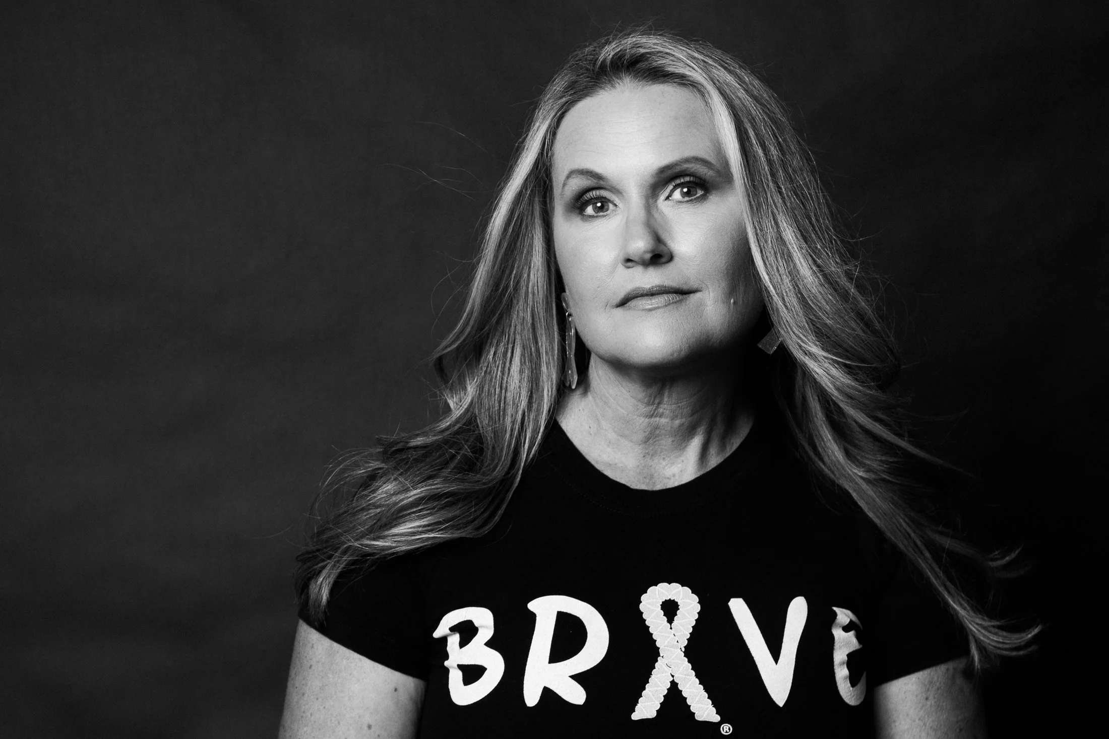 Jenna's modern studio portrait with a confident, don't-mess-with-me expression while wearing her cancer ribbon "Brave" shirt by Amanda Faucett Photography