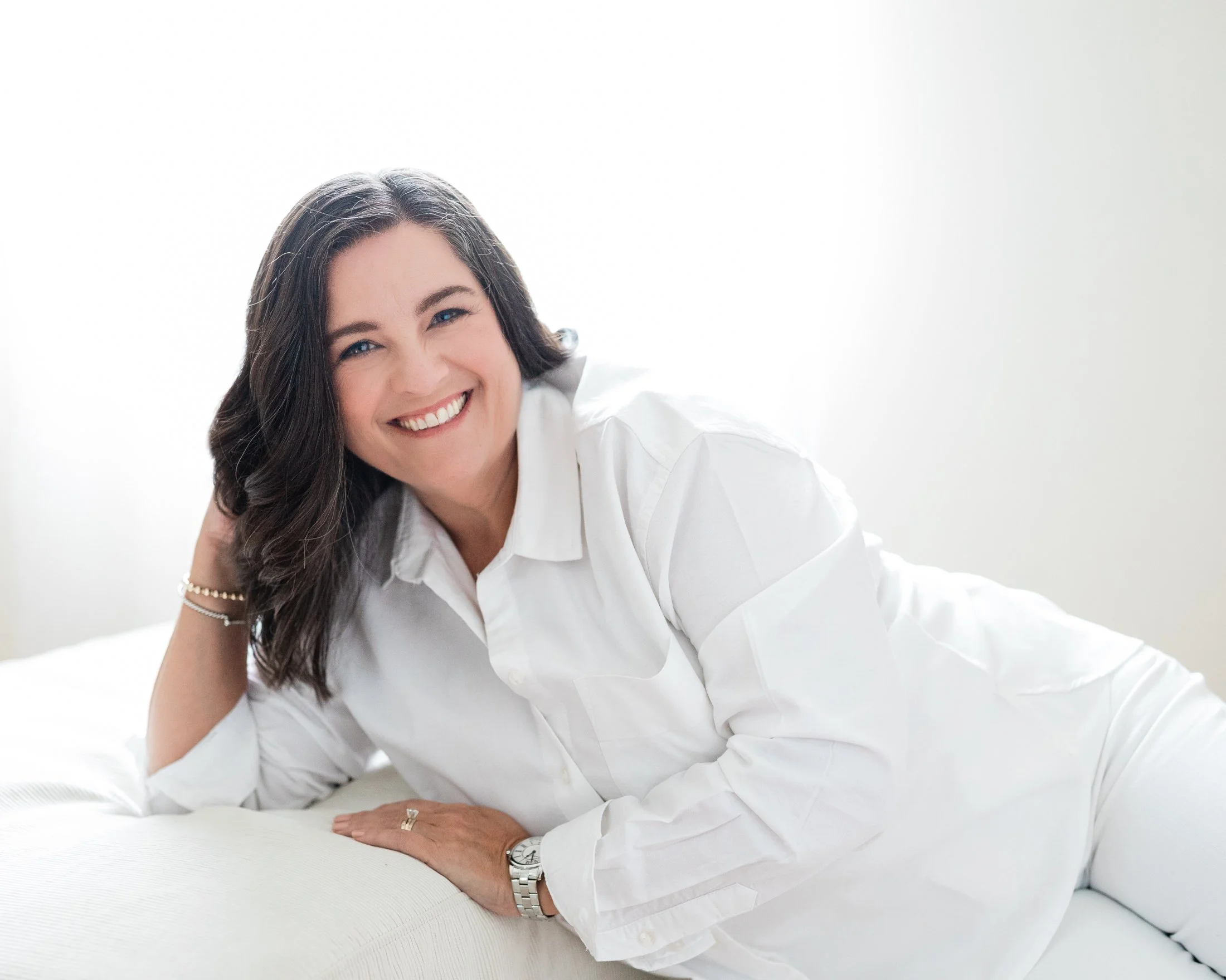Portrait of Aimee in front of a window and dressed in white, featured in the Wise Women | 50 Over 50 Portrait Experience by Houston photographer Amanda Faucett.