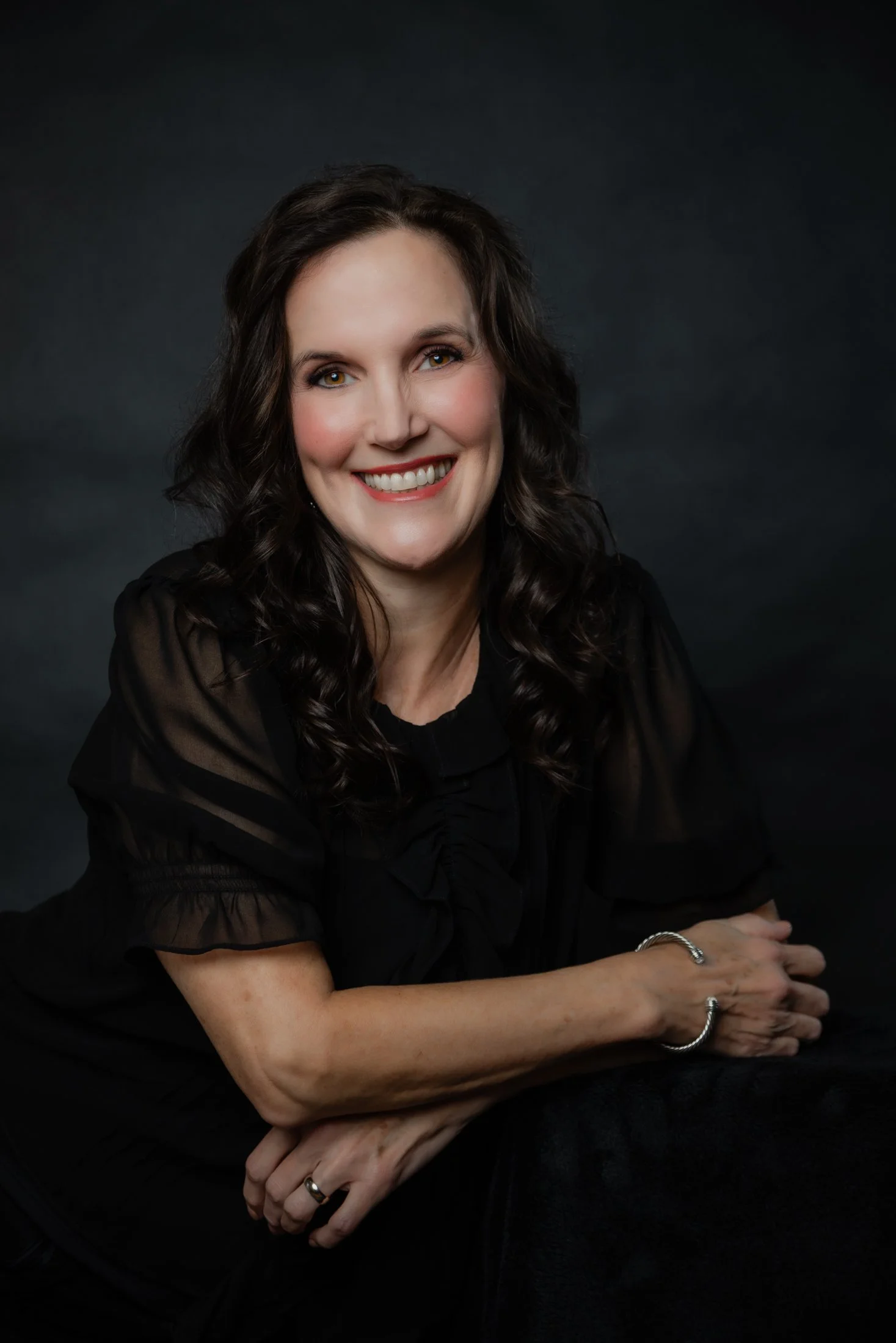 Laura radiates confidence in her 50 Over 50 portrait (wearing a black dress) captured by Houston photographer Amanda Faucett