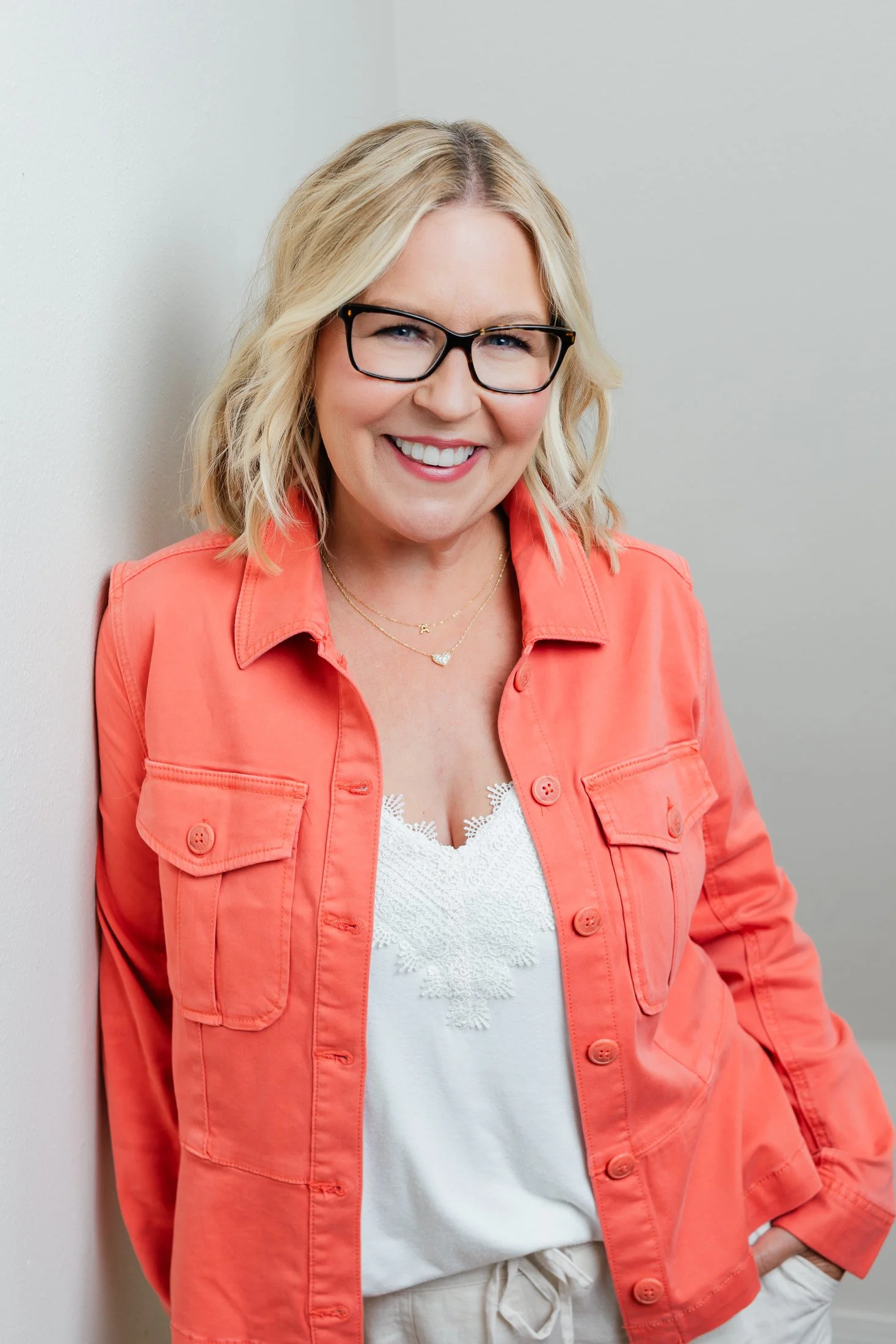 Ann radiates confidence in her 50 Over 50 portrait while wearing a cheerful orange jacket, Captured by Houston photographer Amanda Faucett.