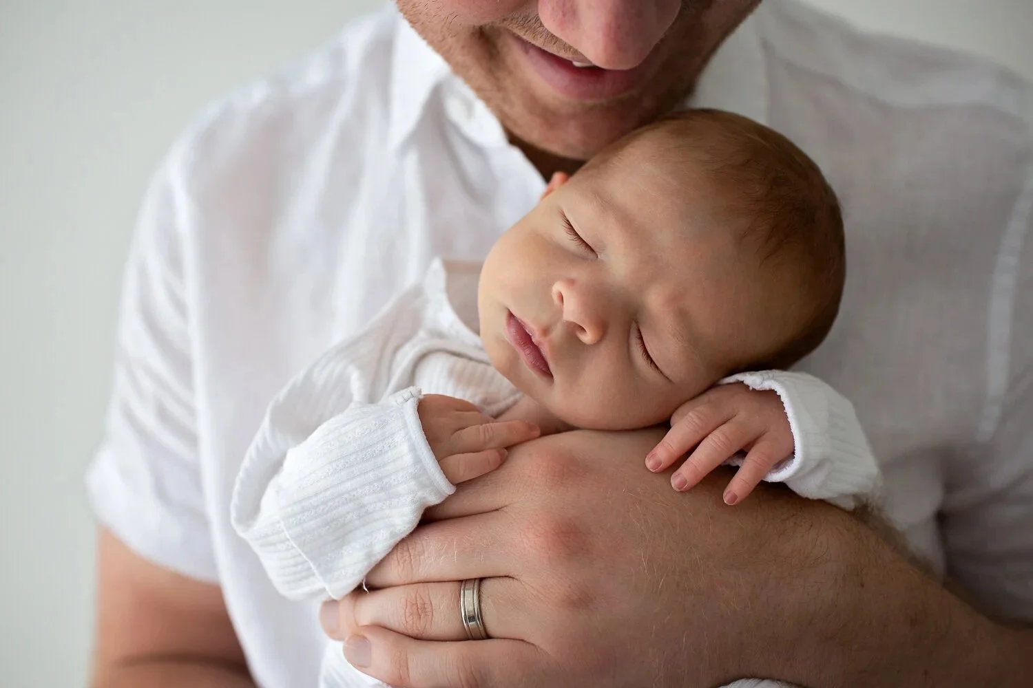 Baby asleep in dad's hands
